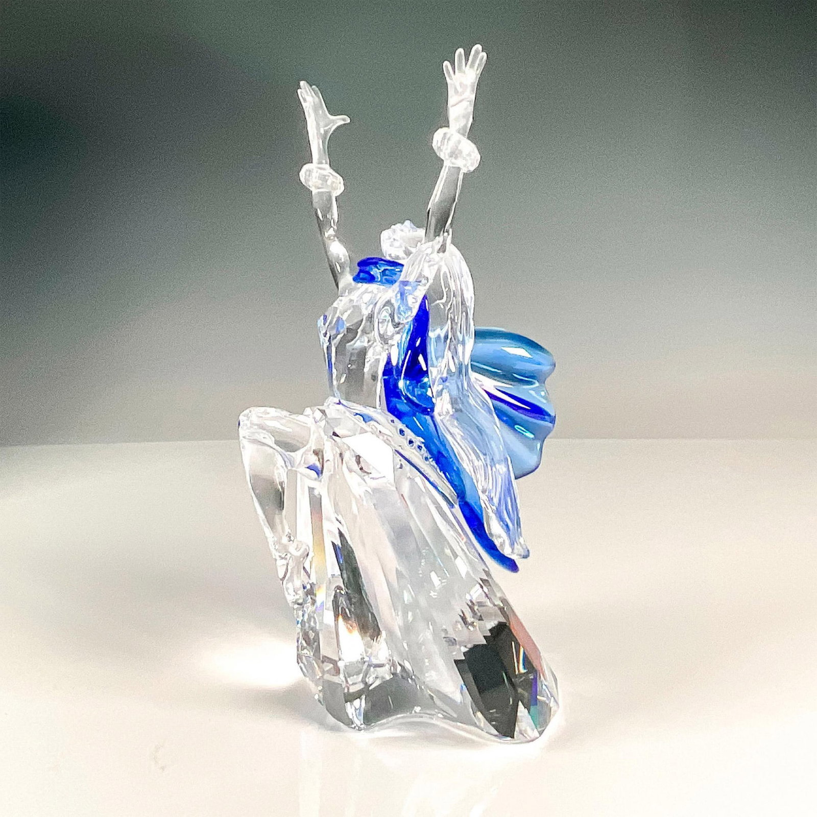 Swarovski Crystal Figurine, Isadora: Multifaceted clear and blue crystal, first of the Magic of Dance trilogy. Swarovski etched backstamp. This item has its original box, 10.75"L x 6.5"W x 5.75"H, and outer box. Issued: 2002 Dimensions: 