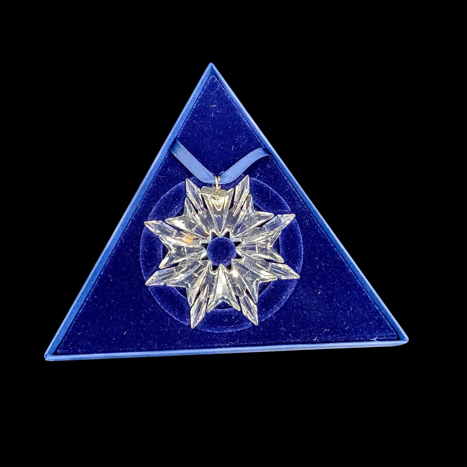 Swarovski Crystal 2003 Annual Christmas Ornament: This retired limited edition Swarovski Christmas tree ornament is made from clear crystal and has 6 points. It also has a metal tag with 2003 etched on it. The box is triangular and each side measures