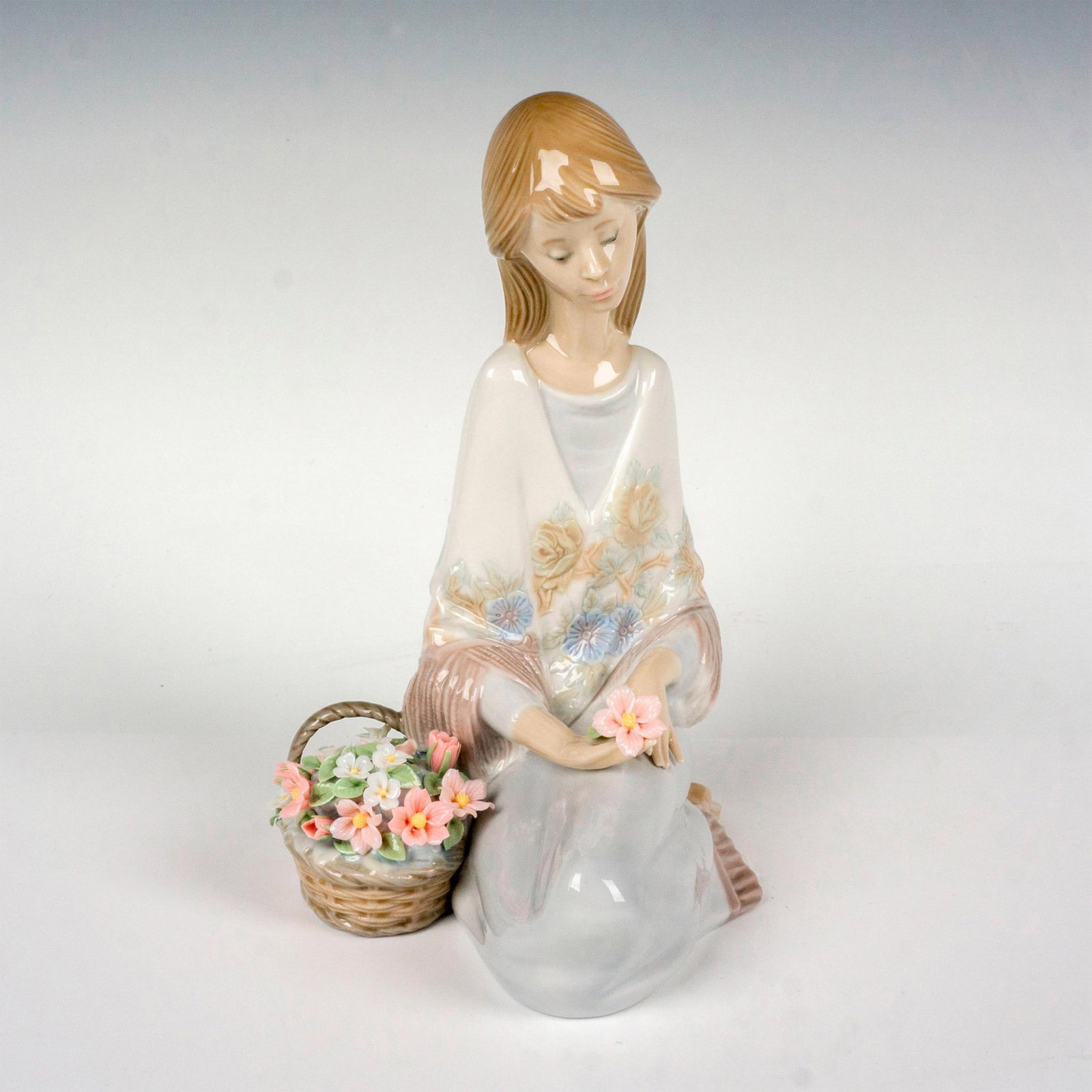 Flower Song 1007607 - Lladro Porcelain Figurine: Glossy finish; Lladro backstamp. Includes original box. Box measures: 6.5"L x 9"W x 10"H. Artist: Juan Huerta Issued: 1988 - 1989 Dimensions: 7.5"H x 5.5"W Manufacturer: Lladro Country of Origin: