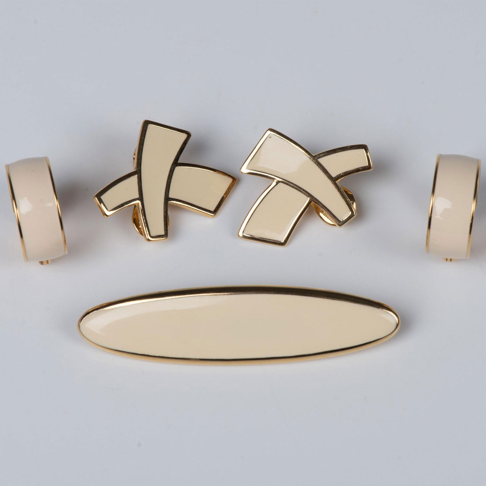 5pc Monet Brooch and Earrings: Timeless pieces. Sleek bar brooch in a creamy white with rounded gold tone edges. Can be worn in either direction. X shape creamy white enamel clip back earrings with a gold tone edge. Small hoop crea