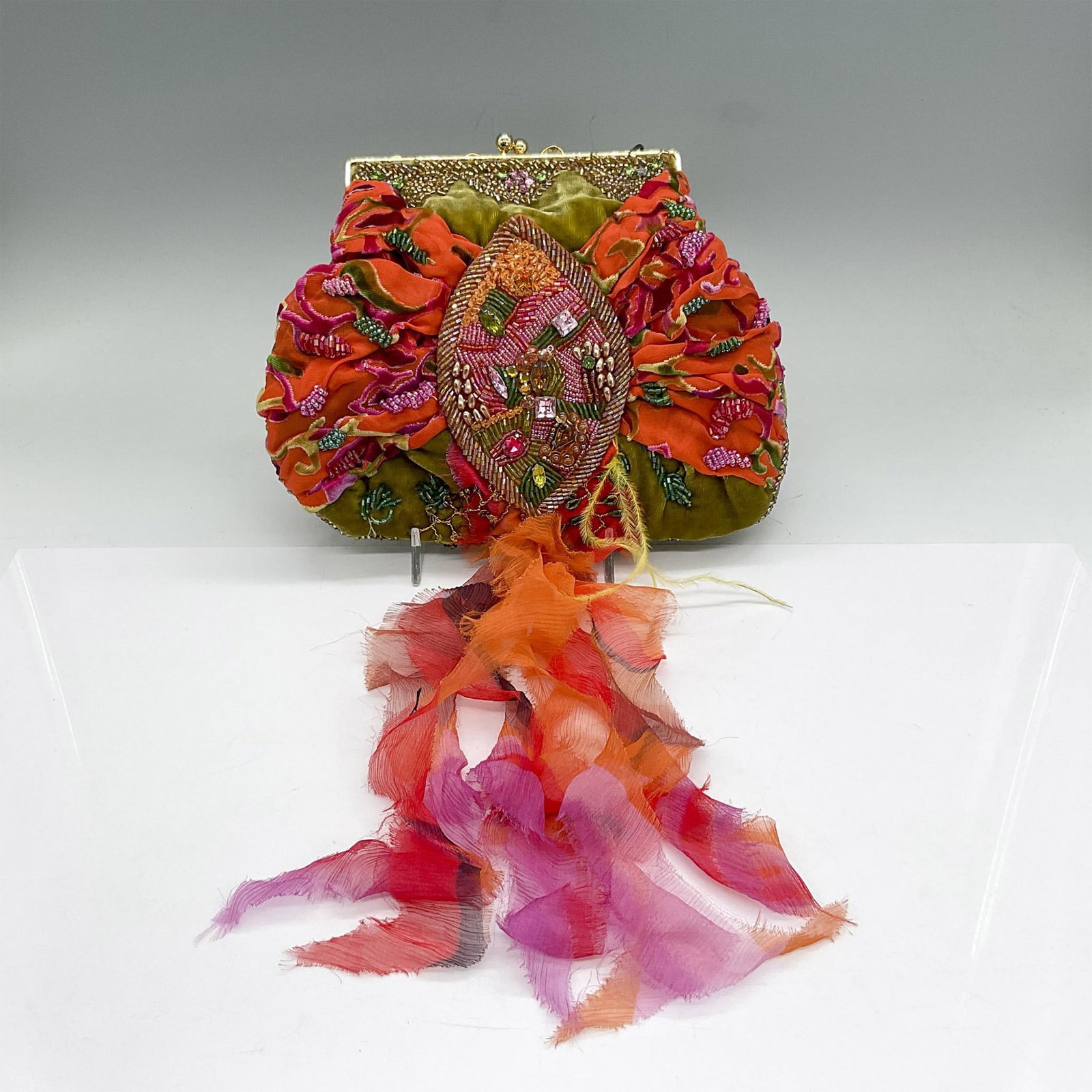 Mary Frances Velvet and Silk Handbag, Olive/Orange/Fuchsia: Velvet and silk handbag with bead decoration and interior pocket. Gold tone hardware. Snap closure with beaded handle. Length of handle is 14.5"L. Mary Frances label inside. Dust bag included. Issued: