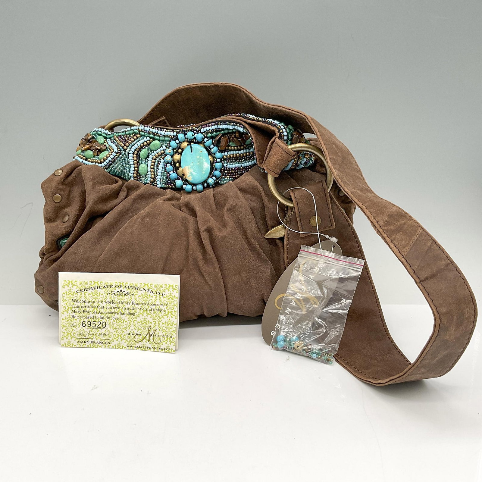 Mary Frances Hand Bag, Rough and Ready: Small microfiber hobo styled bag with brightly colored bead work on top rim and minimal bead work on bottom. Magnetic closure opens to paisley fabric interior and zippered pocket. Dust bag included. M