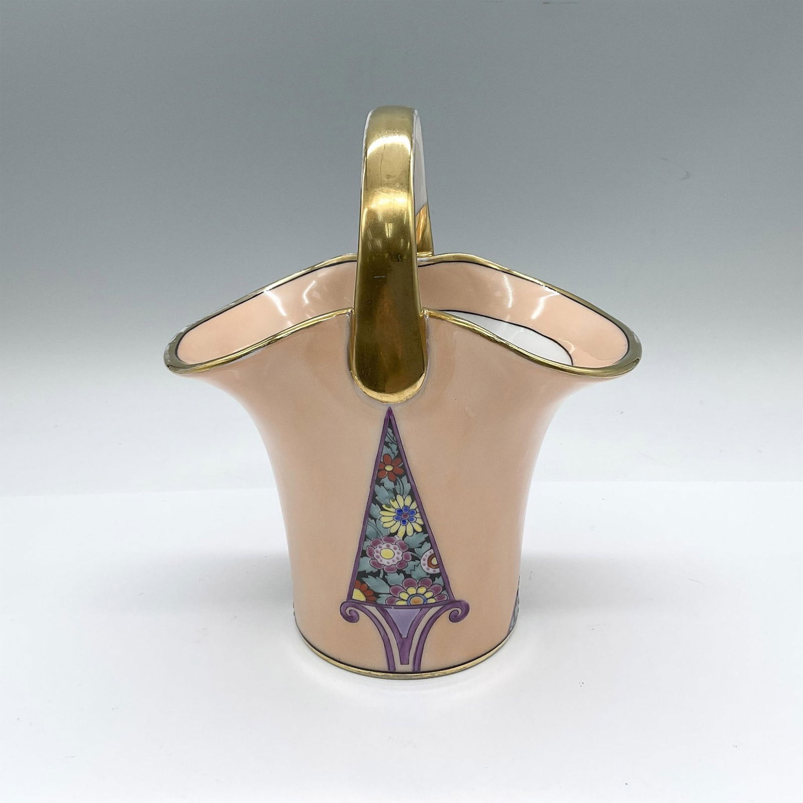 Morimura Bros. Noritake Porcelain Basket Vase: A peach-pink with a gilt handle. Decorated with polychrome enamel flowers. Morimura Bros. backstamp. Issued: 20th century Dimensions: 6.25"L x 4.75"W x 7.25"H Manufacturer: Morimura Bros. Country of O