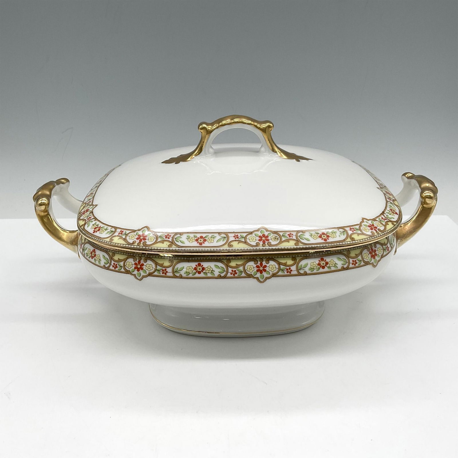 Limoges Vignaud Porcelain Serveware, Square Covered Dish: Elegant gilt banded design of red and yellow floral pattern on this covered dish. Handles and base trim also have gilt accents. Limoges Vignaud France Loeser's backstamp. VIG167. Issued: c. 1911 - 193