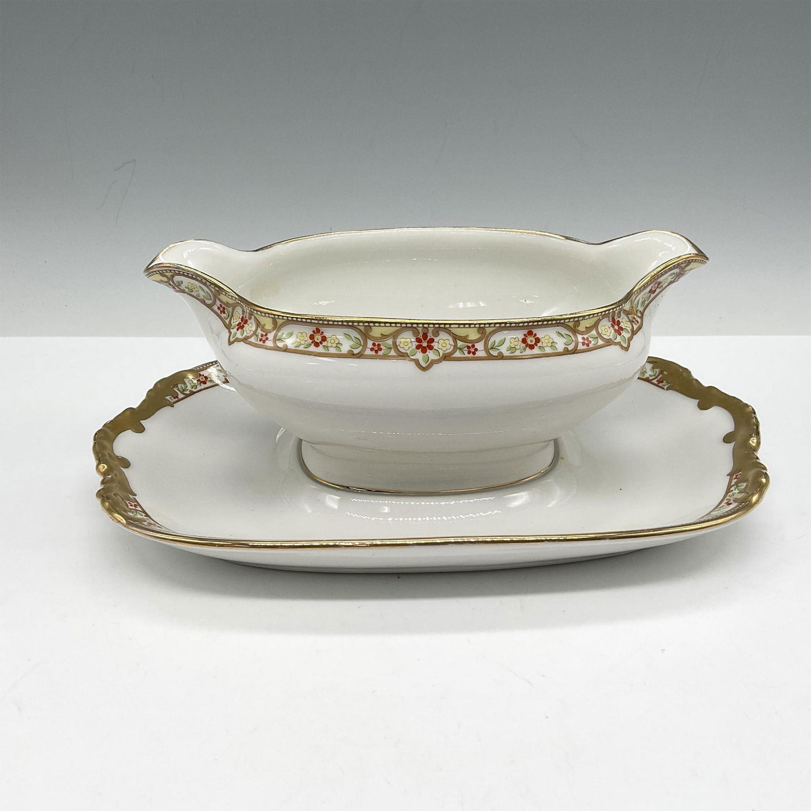Limoges Vignaud Porcelain Serveware, Sauce Boat w/Underplate: Lovely serveware features an elegant design of a red and yellow floral band on white, accentuated by gilt trim. Limoges Vignaud Loeser's backstamp. VIG167. Issued: c. 1911 - 1938 Dimensions: 9"L x 6.5
