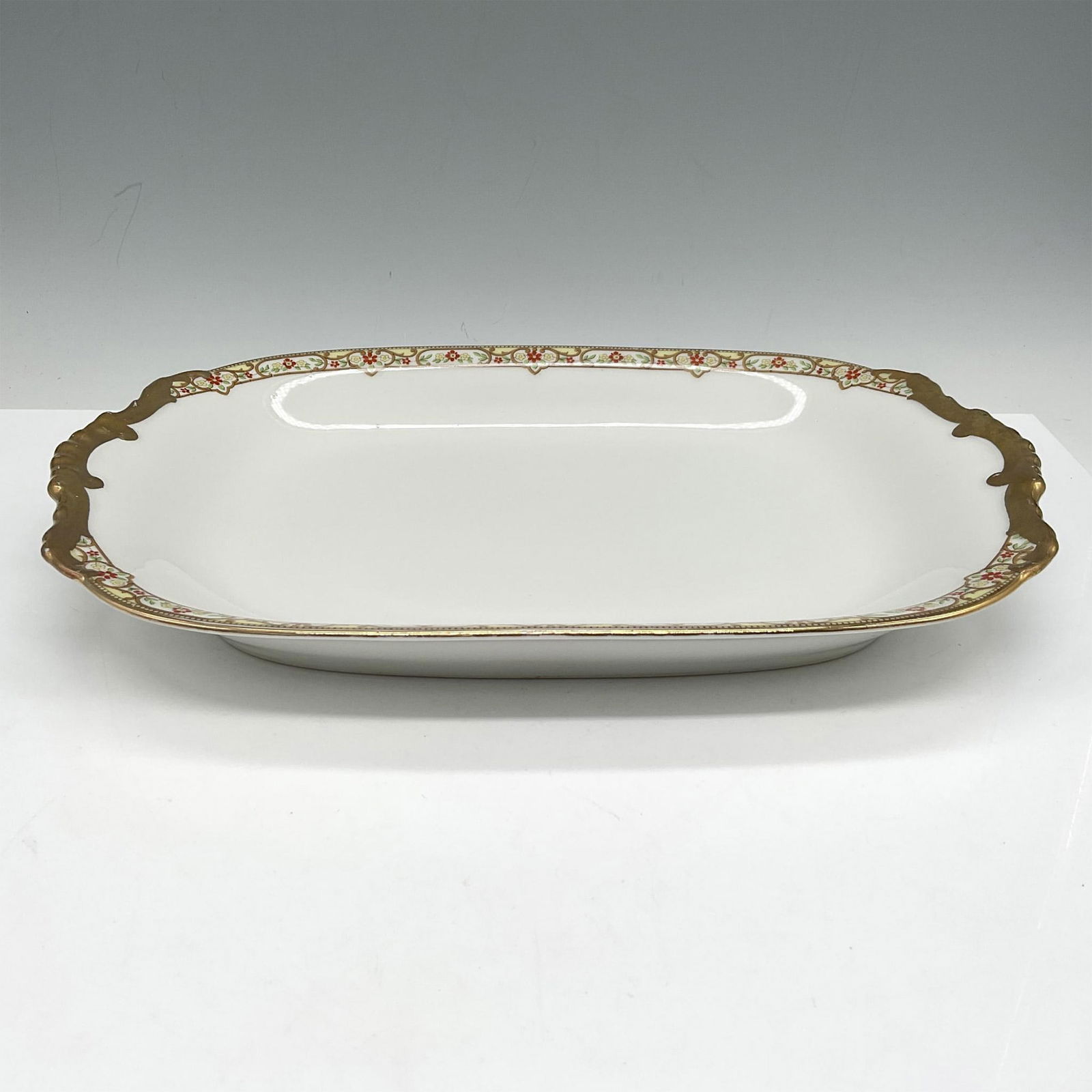 Limoges Vignaud Porcelain Serveware, Small Oval Platter: Elegant gilt banded design of red and yellow floral pattern on platter. Limoges Vignaud France Loeser's backstamp. VIG167. Issued: c. 1911 - 1938 Dimensions: 12"L x 8"W x 1.5"H Manufacturer: Limoges V