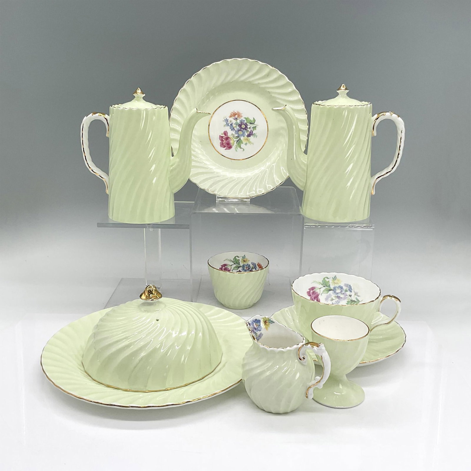 12pc Aynsley Tea/Breakfast Set, Covered Cheese Plate: Bone china tea service in pale green, raised ripple swirl, colorful flowers, gold rims and accents. Aynsley backstamp. Two small lidded teapots 5.75"L x 3"W x 5.5"H. Creamer pitcher 3.25"L x 2.25"W x 