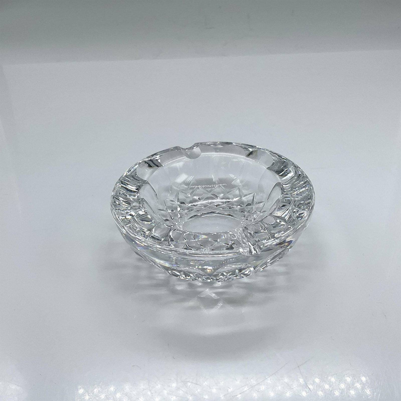 Waterford Crystal Ashtray: Small clear crystal ashtray with crisscross and thumb print design. Waterford mark. Dimensions: 1.25"H x 3.25" dia Manufacturer: Waterford Country of Origin: Ireland