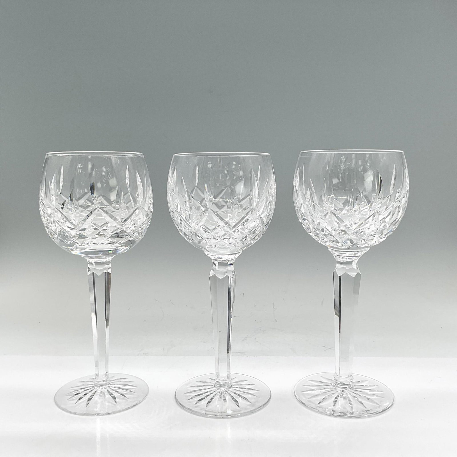 3pc Waterford Crystal Hock Wine Glasses, Lismore: Three clear stemmed crystal glasses with crisscross, leaf and sunburst etched design. Waterford mark. Dimensions: 7.5"H x 2.75" dia Manufacturer: Waterford Country of Origin: Ireland