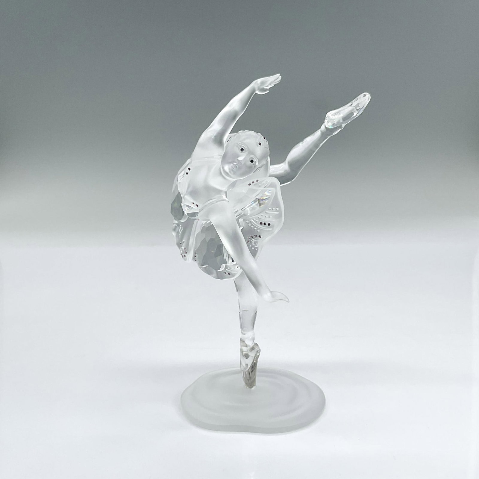 Swarovski Crystal Figurine, Ballerina: Frosted and clear crystal figure of a ballerina poised en pointe. Delicate pink crystals decorate throughout; blue crystals for eyes. Part of the When we were Young collection. Swarovski mark. Include