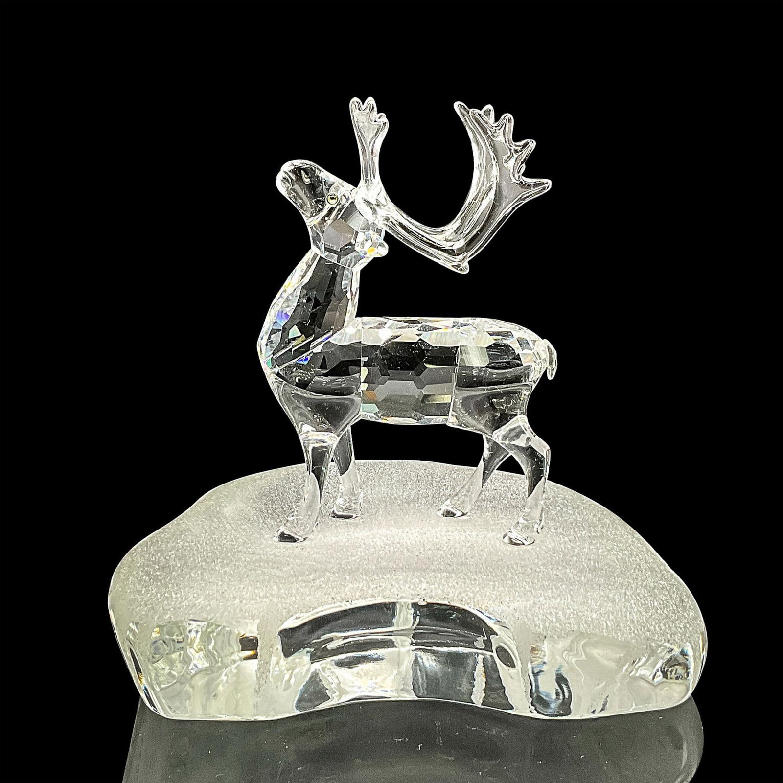 Swarovski Silver Crystal Figurine, Reindeer on Iceberg: Clear faceted crystal figure of a standing reindeer with blue/yellow/green eyes. Retired; part of the Exquisite Accents collection. Swarovski mark. Item number 7475NR000602. This item has its original