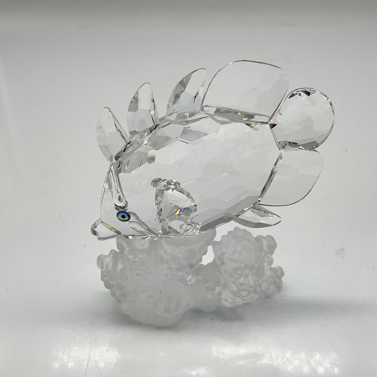 Swarovski Silver Crystal Figurine, Butterfly Fish: This figural is part of the South Seas group. Clear faceted fins and body with aquamarine crystal eyes peers at the frosted crystal coral it is swimming over. Swarovski backstamp. 7644 077 000. This i