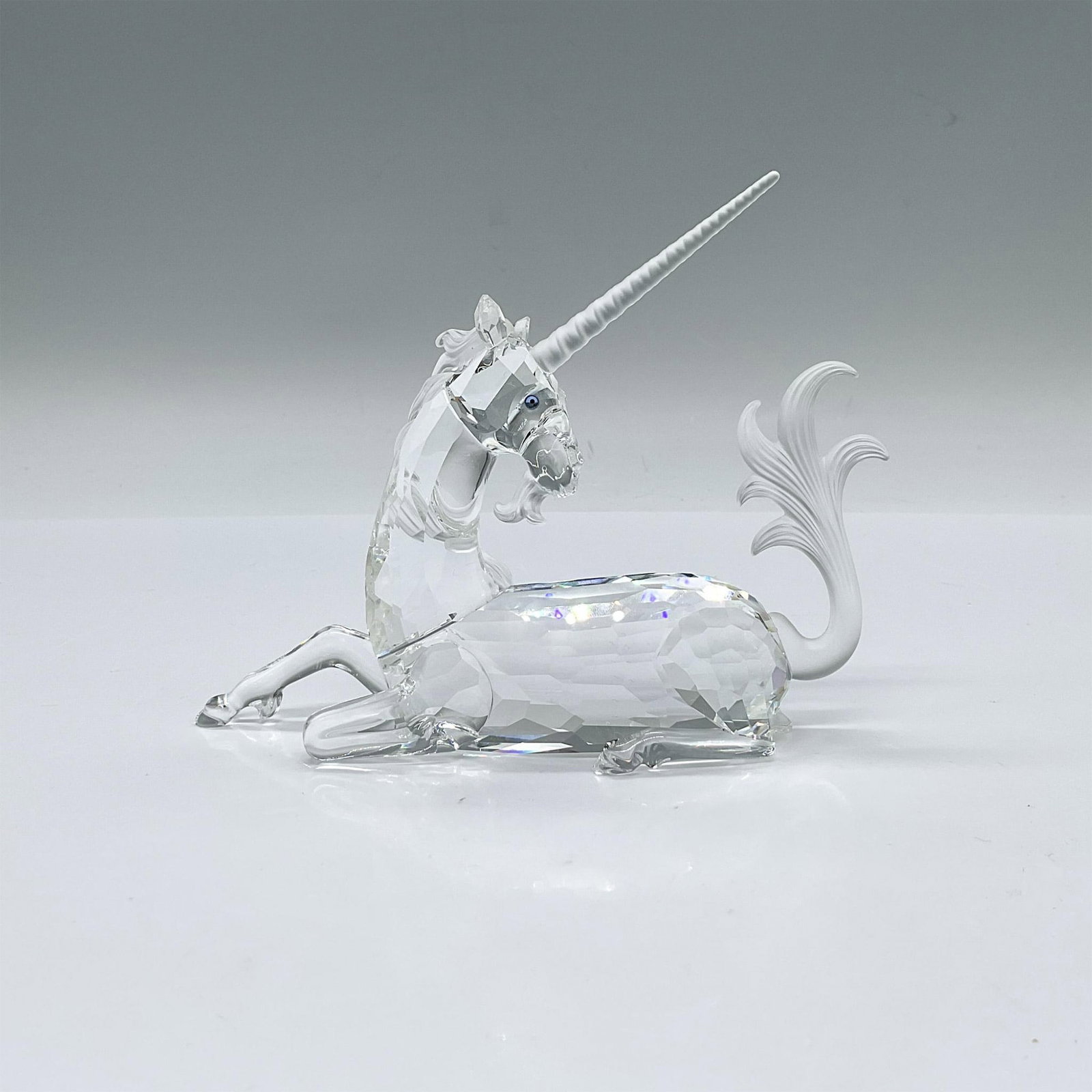Swarovski Crystal Figurine, The Unicorn: First of the Fabulous Creatures trilogy. A resting mythical horned horse with a clear body. Frosted horn and tail. Swarovski swan marked. Artist: Martin Zendron Issued: 1996 Dimensions: 5.25"L x 1.5"W