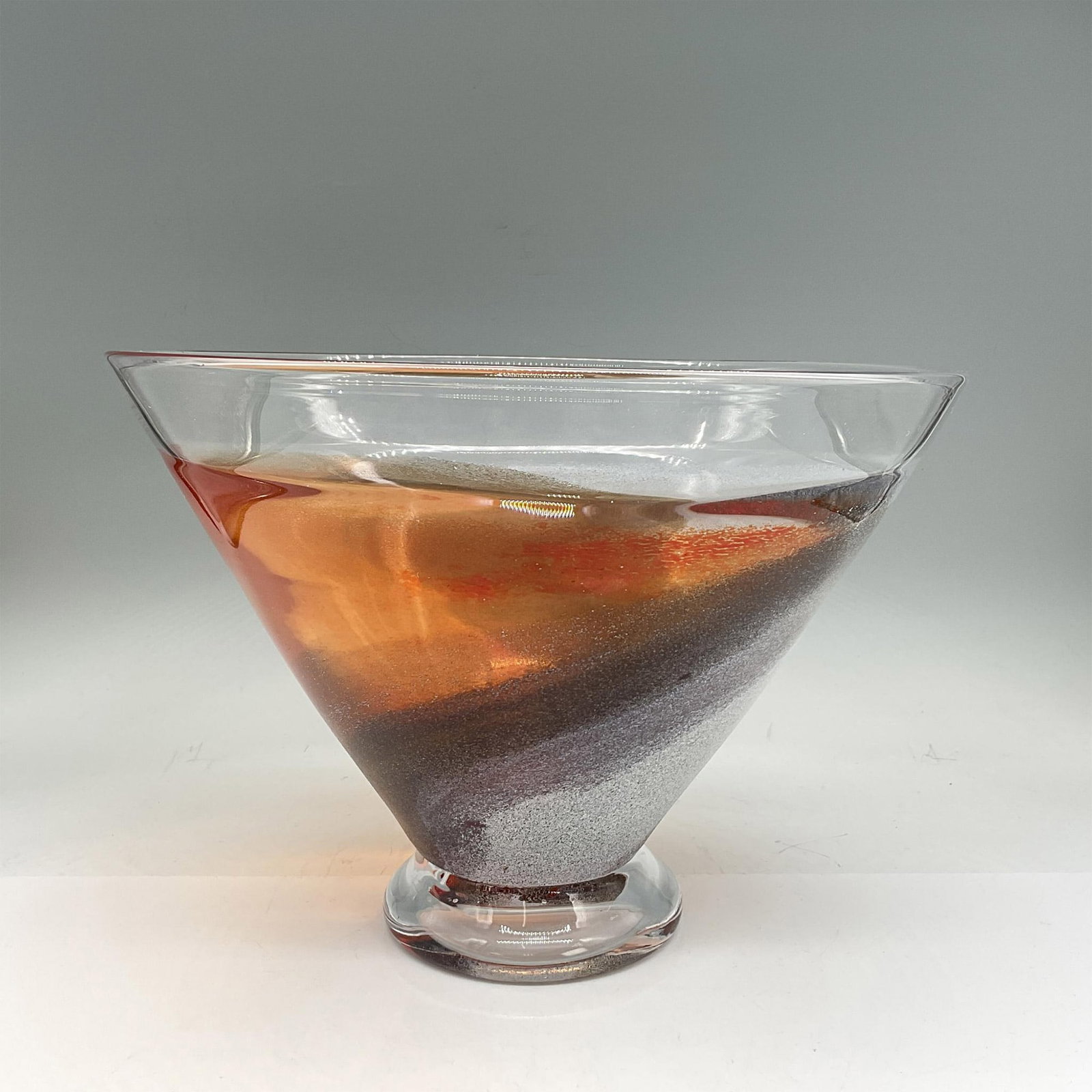 Kosta Boda Glass Twister Bowl: Unusual decorative bowl in dark orange, brown and silver. Kosta Boda etched signature. Artist: Kjell Engman Dimensions: 10.5"H x 7.5" dia Manufacturer: Kosta Boda Country of Origin: Sweden