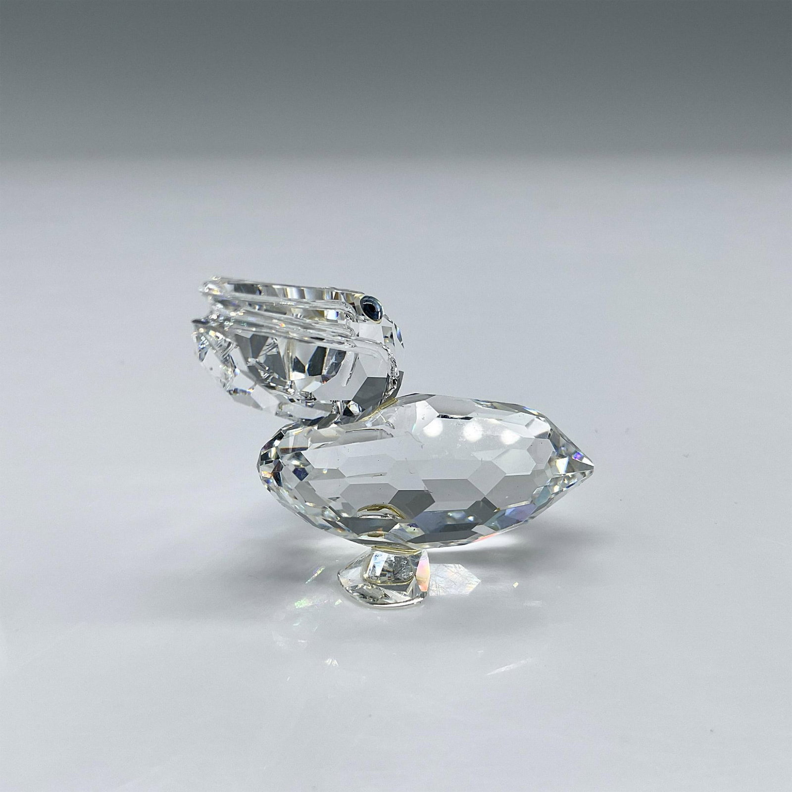 Swarovski Silver Crystal Figurine, Pelican: Part of the Feathered Friends collection. Clear faceted crystal body with blue-green eyes. Swarovski marking. This item has its original box: 3.25"W x 2.5"H. Artist: Anton Hirzinger Issued: 1993-2002 
