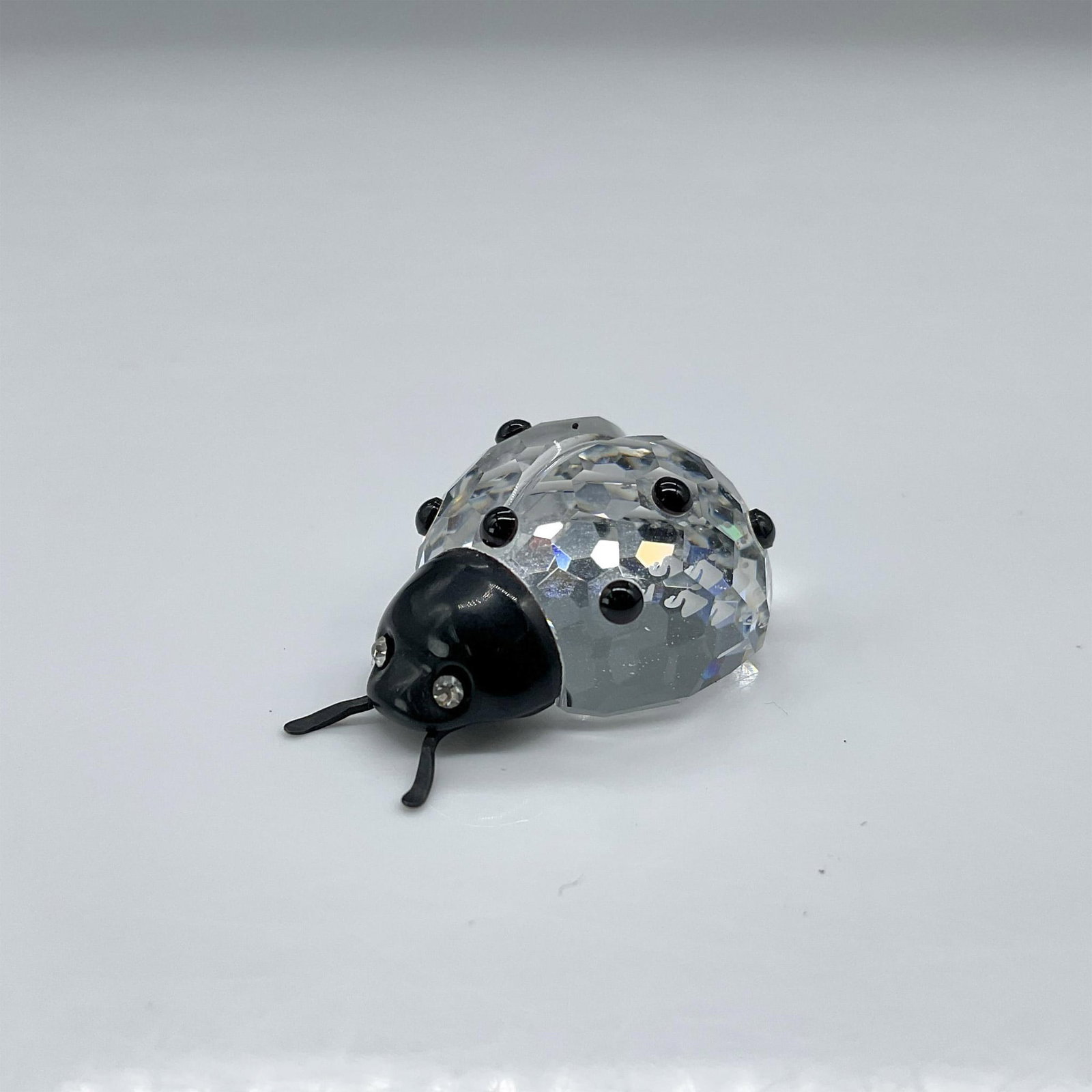 Swarovski Crystal Figurine, Ladybug: A lovely clear crystal ladybug that is decorated with a black crystal face and black crystal spots. Swarovski backstamp. This item has its original box. Dimensions of the box: 2.5"H x 3.25" dia. Artis
