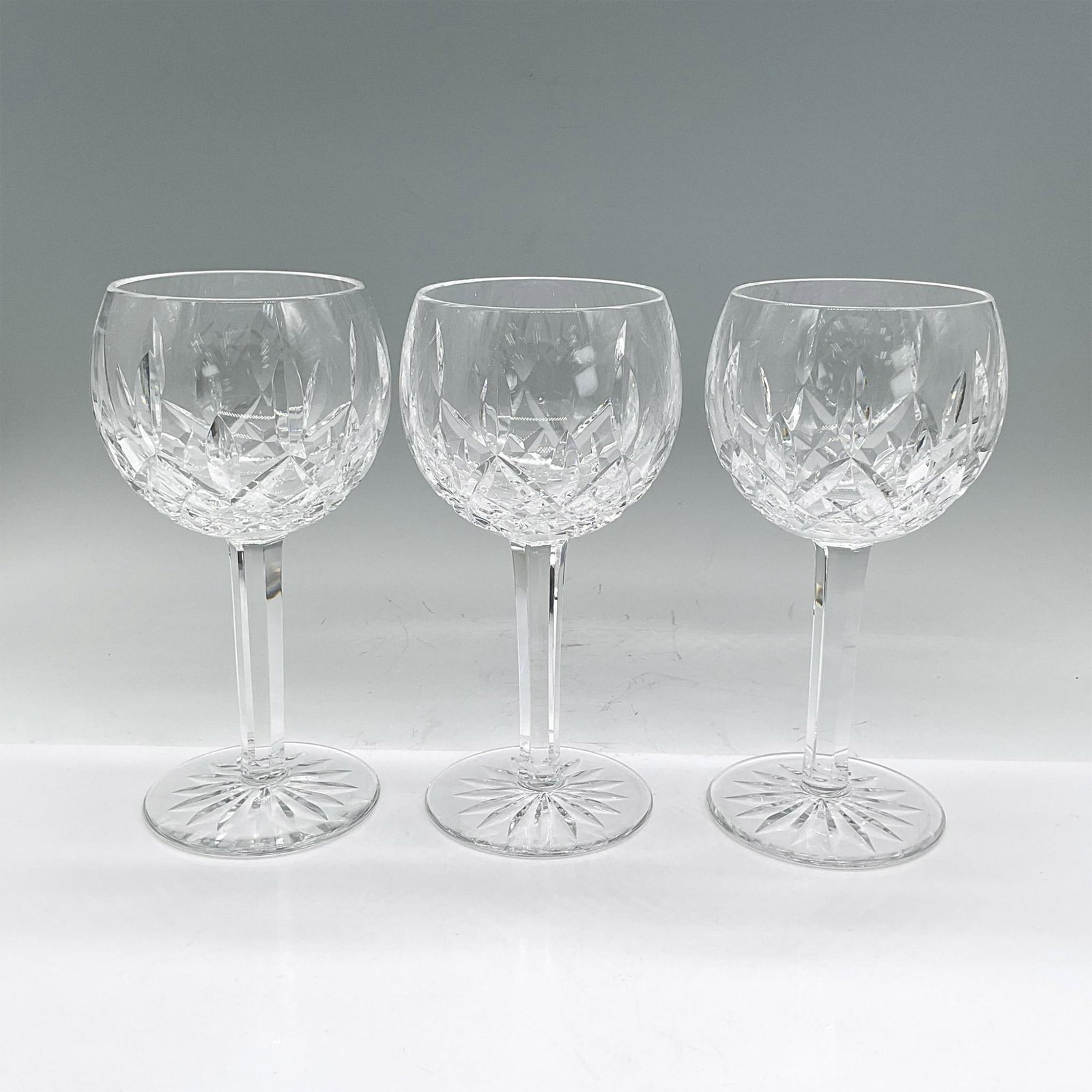 3pc Waterford Crystal Balloon Wine Glasses, Lismore: Three clear stemmed crystal glasses with crisscross, leaf and sunburst etched design. Waterford mark. Dimensions: 7.25"H x 3.5" dia Manufacturer: Waterford Country of Origin: Ireland