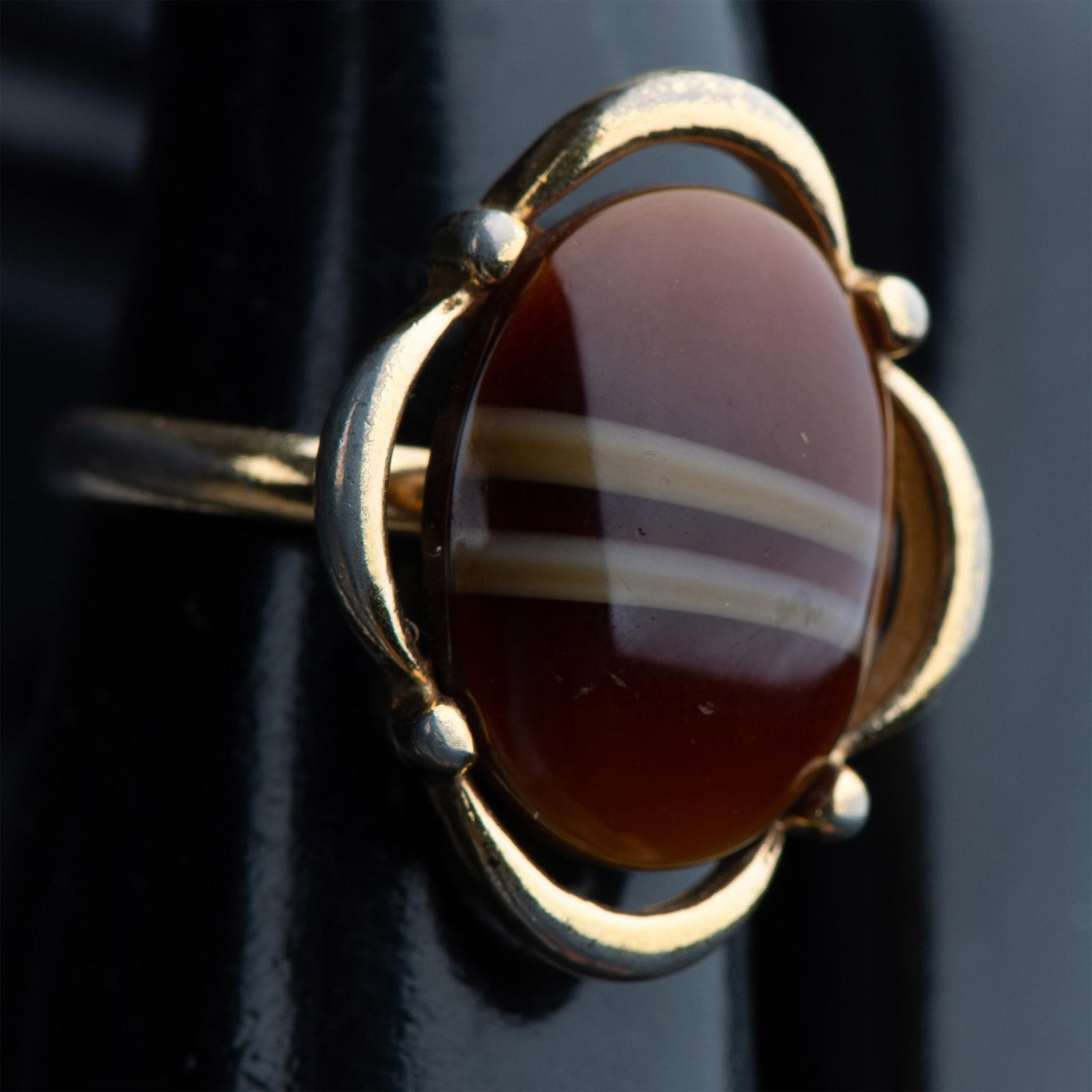 Circa 1970s Sarah Coventry Jupiter Ring: This beautiful ring has a faux tiger's eye center stone in a gold tone open scalloped setting. It has an adjustable band to fit any finger and the Sarah Coventry mark inside. Manufacturer: Sarah Coven
