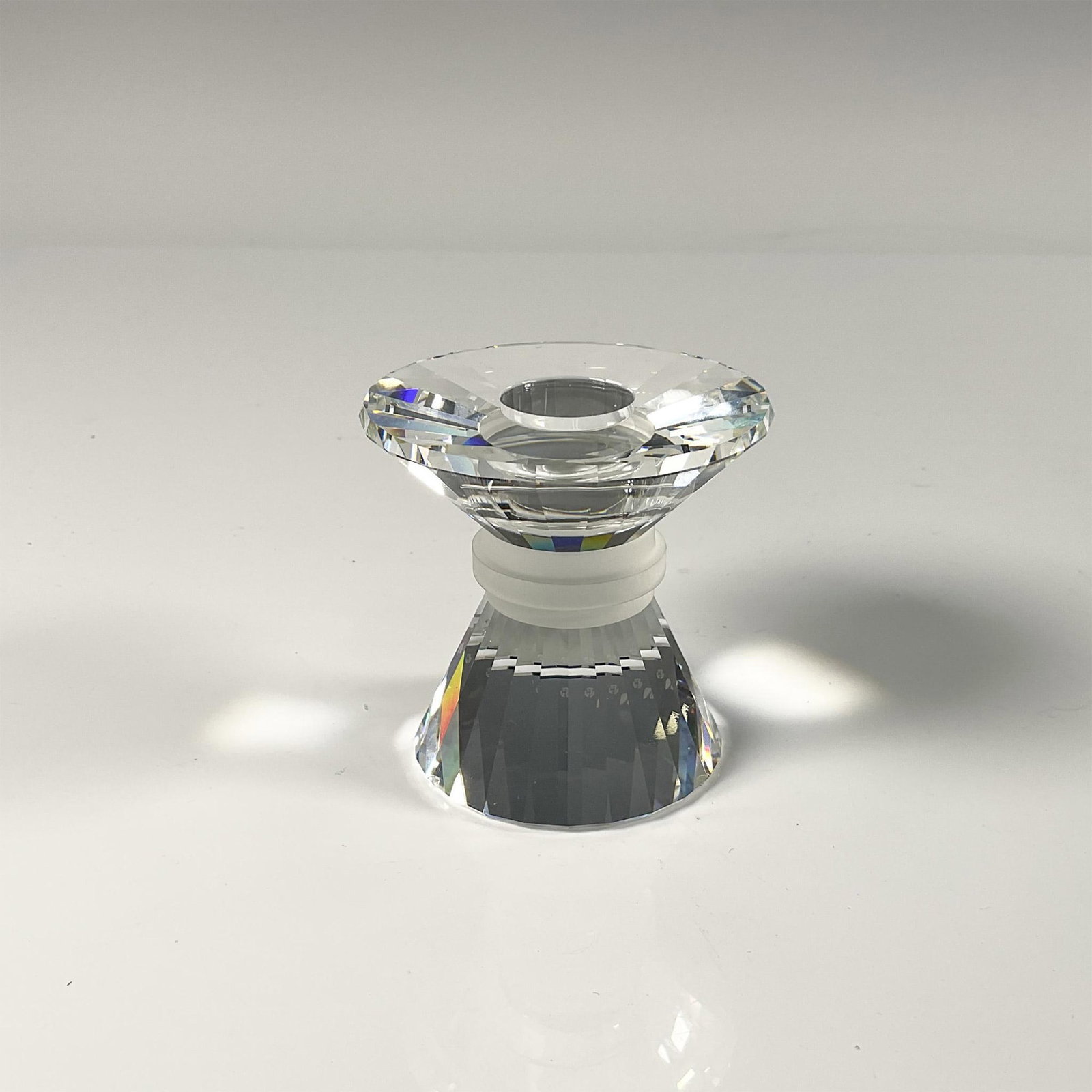 Swarovski Lead Crystal Candleholder: Dazzling faceted clear crystal with frosted center rim. Swarovski etched backstamp. Includes the original box, dimensions: 6''H x 5''dia. Issued: 20th century Dimensions: 2.5''H x 2.75''dia Manufactur
