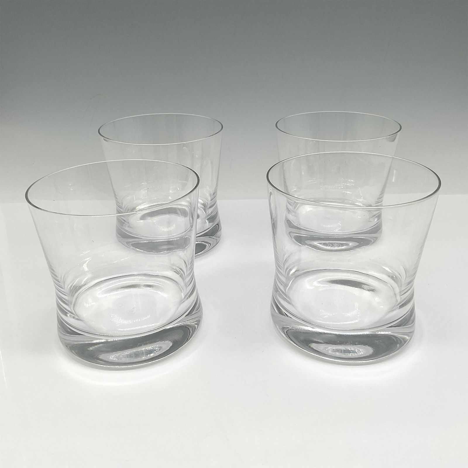 Orrefors Crystal Tumblers Bar Series, Sky: Set of 4 clear crystal tumblers with weighted bottom. Orrefors mark. This item has its original box: 7.25"L x 7.25"W x 4"H. Artist: Erika Lagerbielke Issued: 21st century Dimensions: 3.75"H x 3" dia.
