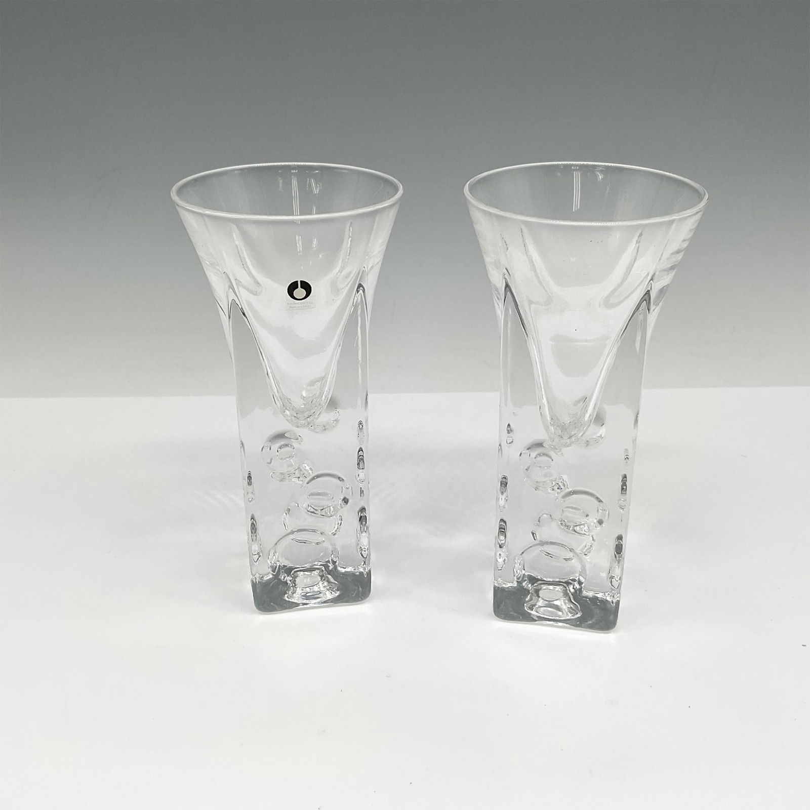 2pc Pukeberg Glass Mid Century Modern Shot Glasses: Round glass extending to square base designed with bubbles. Pukeberg Sweden mark. Artist: Jan Johansson Issued: 21st century Dimensions: 1.25"L x 1.25"W x 5"H Manufacturer: Pukeberg Country of Origin