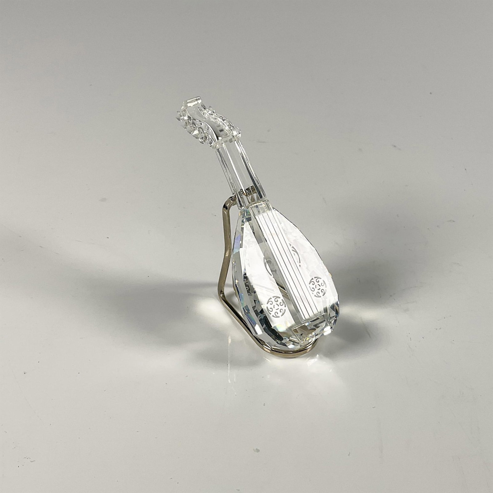 Swarovski Crystal Figurine, Lute Mandolin: Facetted clear crystal, from the Crystal Melodies collection, includes metal stand and original box, dimensions: 6.5''H x 3.25''dia. Issued: 20th century Dimensions: 1''L x 1.25''W x 3.25''H Manufactu