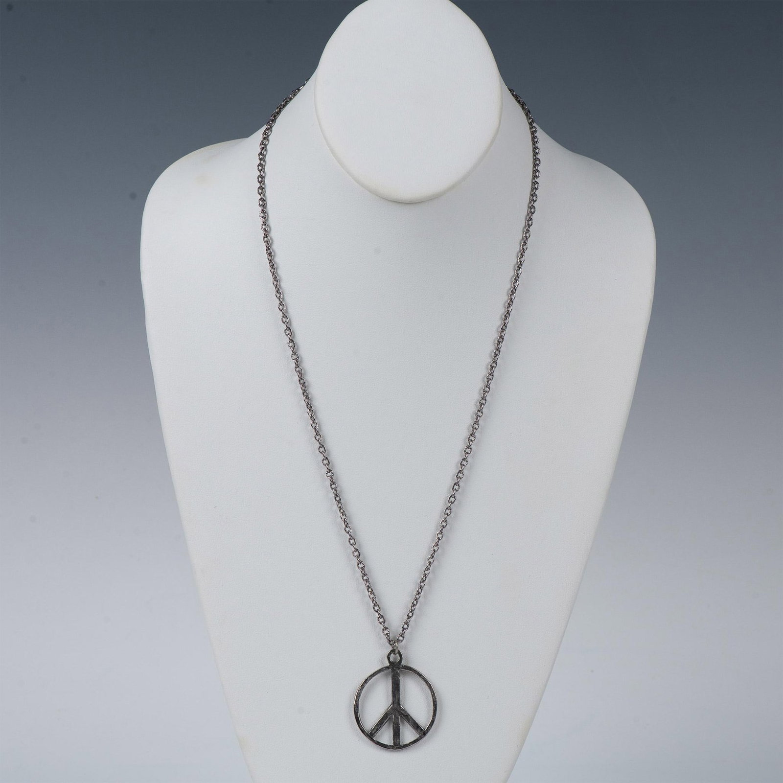 Cute Peace Sign Pendant Necklace: Dark silver metal peace sign pendant measuring 1.25"L x 1.25"W. The chain has a spring ring clasp and measures 23.5"L.