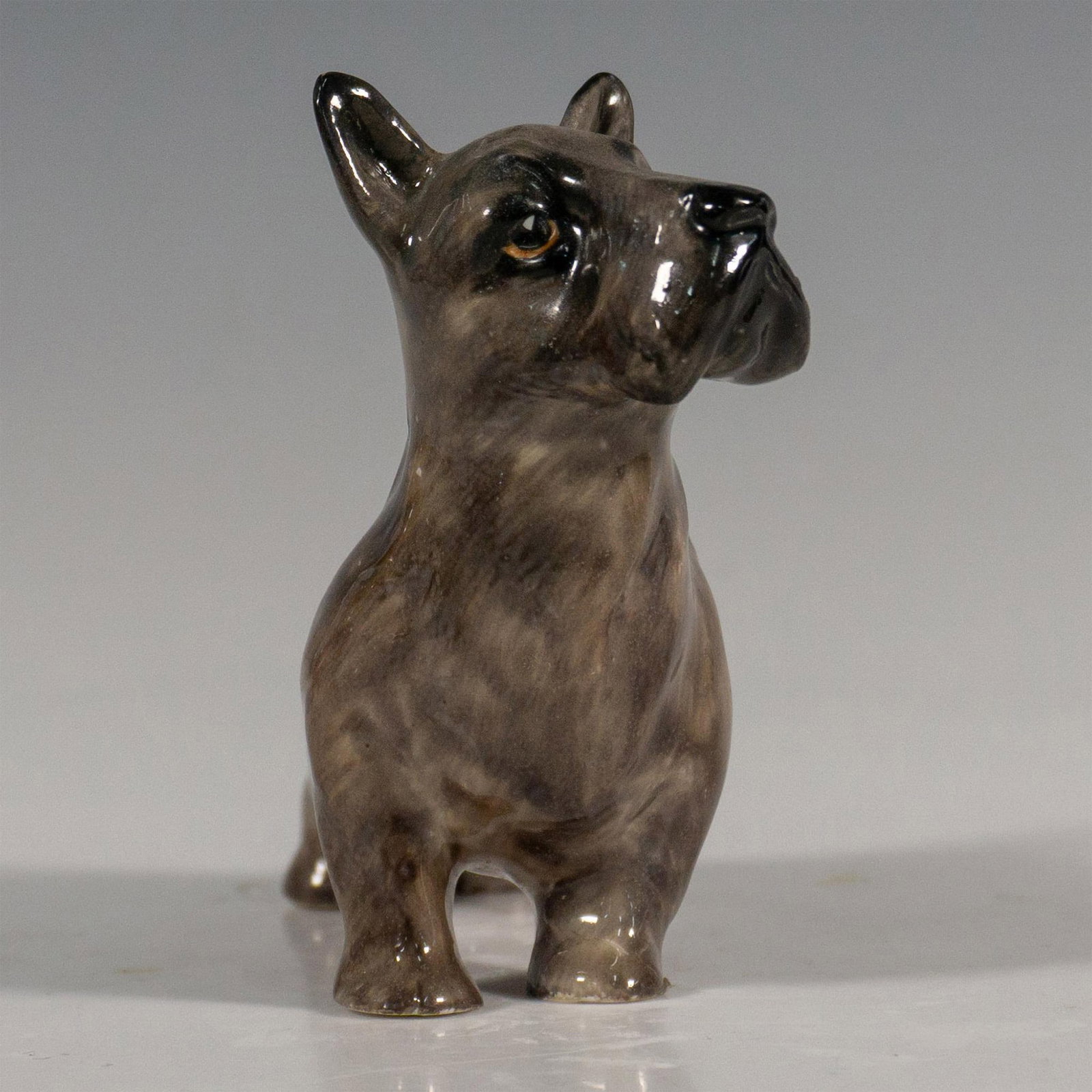 Scottish Terrier HN981 - Royal Doulton Animal Figurine: Standing gray terrier. Gloss finish. Backstamp Royal Doulton England R in green. Impress marks square and a star. Issued: 20th century Dimensions: 5"L x 2"W x 3.25"H Manufacturer: Royal Doulton Countr