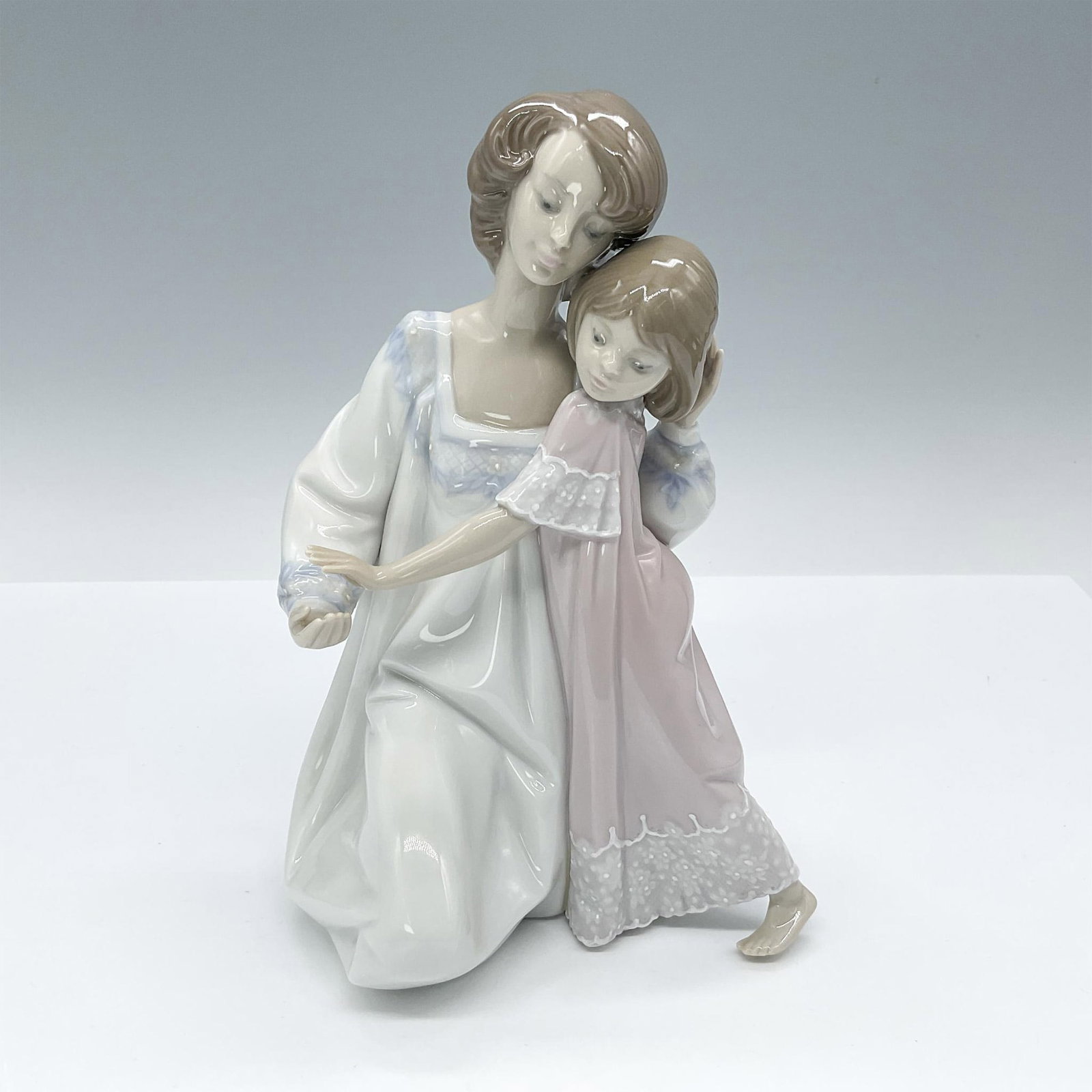 Lladro Porcelain Figurine, Good Night 1005449: Porcelain figurine sculpture portraying a tender moment between a mother and her daughter, as the mother kneels to lovingly bid her daughter goodnight. Lladro backstamp. Artist: Juan Huerta Issued: 19