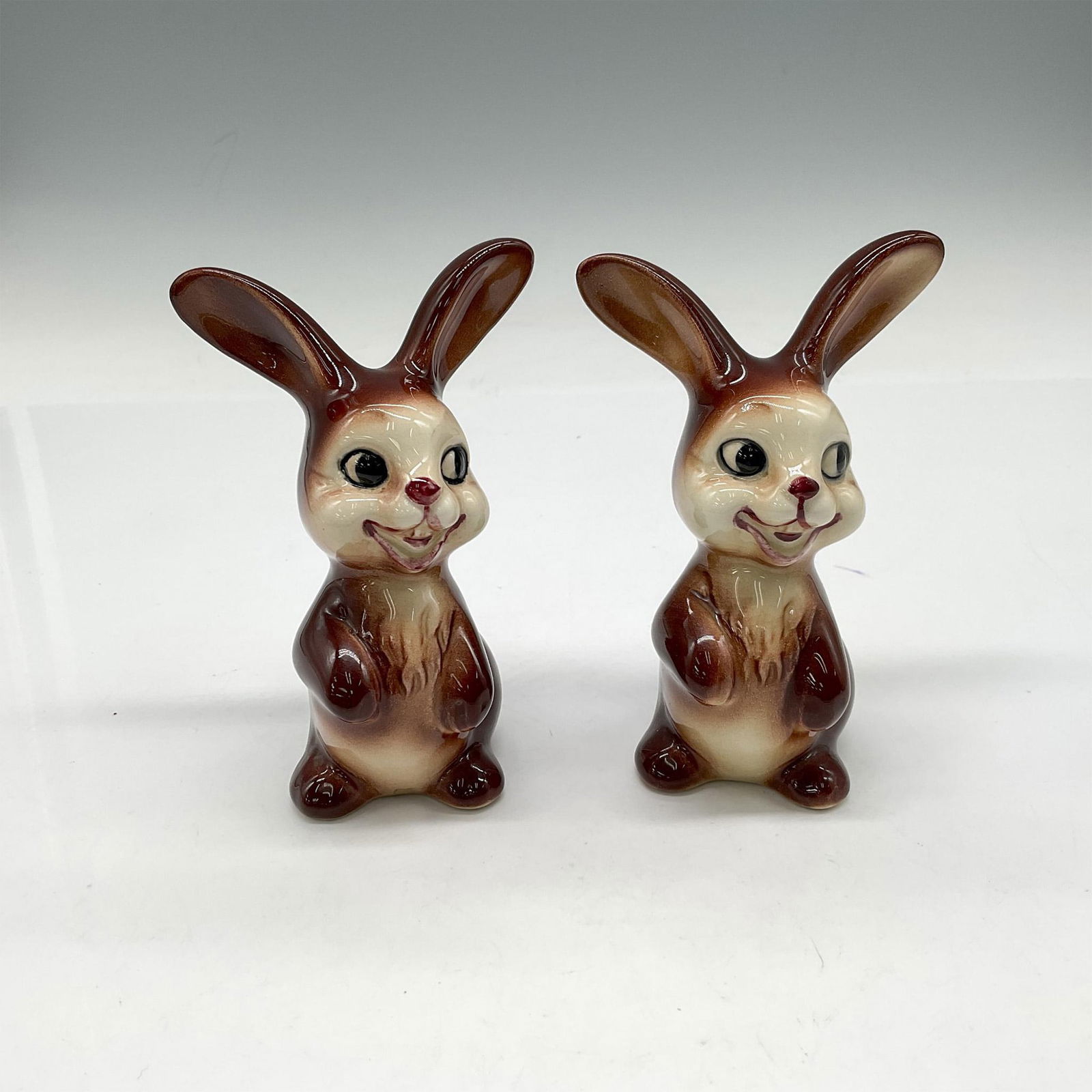 2pc Goebel Porcelain Bunnies: Adorable brown bunnies with cream colored face and belly. Goebel backstamp. KT 173I. Issued: 1960 - 1972 Dimensions: 1.75"L x 2.25"W x 4"H Manufacturer: Goebel Hummel Country of Origin: Germany