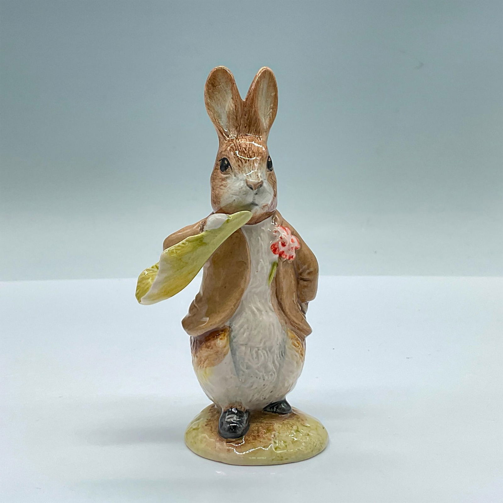 Royal Albert Beatrix Potter Figurine, Benjamin Bunny Ate a Lettuce: Glossy porcelain features Benjamin Ate A Lettuce Leaf. Modeled by Martyn Alcock. Royal Albert Beatrix Potter backstamp. Issued: c. 1992 Dimensions: 2.25''L x 2''W x 5''H Manufacturer: Royal Albert Cou