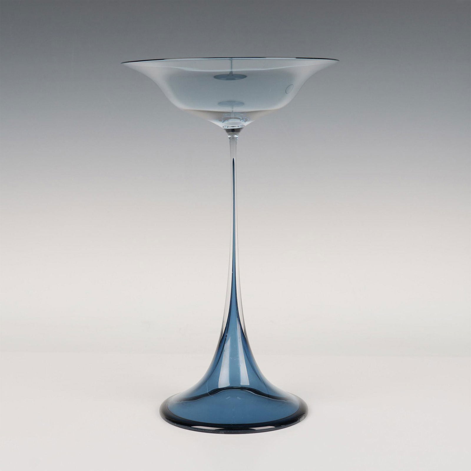 Orrefors by Nils Landberg Tulpan Vase: A periwinkle blue Swedish glass with a flared top and bottom. Orrefors Expo etched on the underside. Artist: Nils Landberg Issued: 1950s Dimensions: 8"W x 13.25"H Manufacturer: Orrefors Country of Or