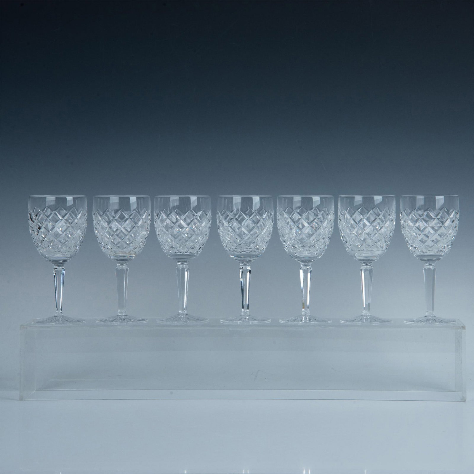 7pc Waterford Crystal Red Wine Glasses, Comeragh: This exquisite hand-cut and polished set includes seven red wine glasses with crisscross pattern on bowl and starburst on base. Waterford backstamp. Dimensions: 7"H x 3" dia. Manufacturer: Waterford C