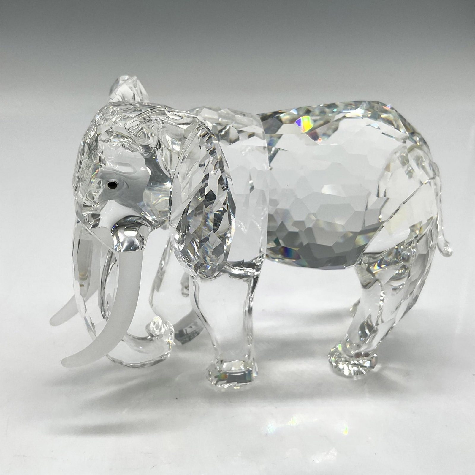 Swarovski Silver Collectors Society, The Elephant: 1993 Inspiration Africa figural this strong creature is depicted walking with trunk down, ears spread wide. Created from clear crystal with multi facets, inset black crystal eyes, frosted crystal tusk