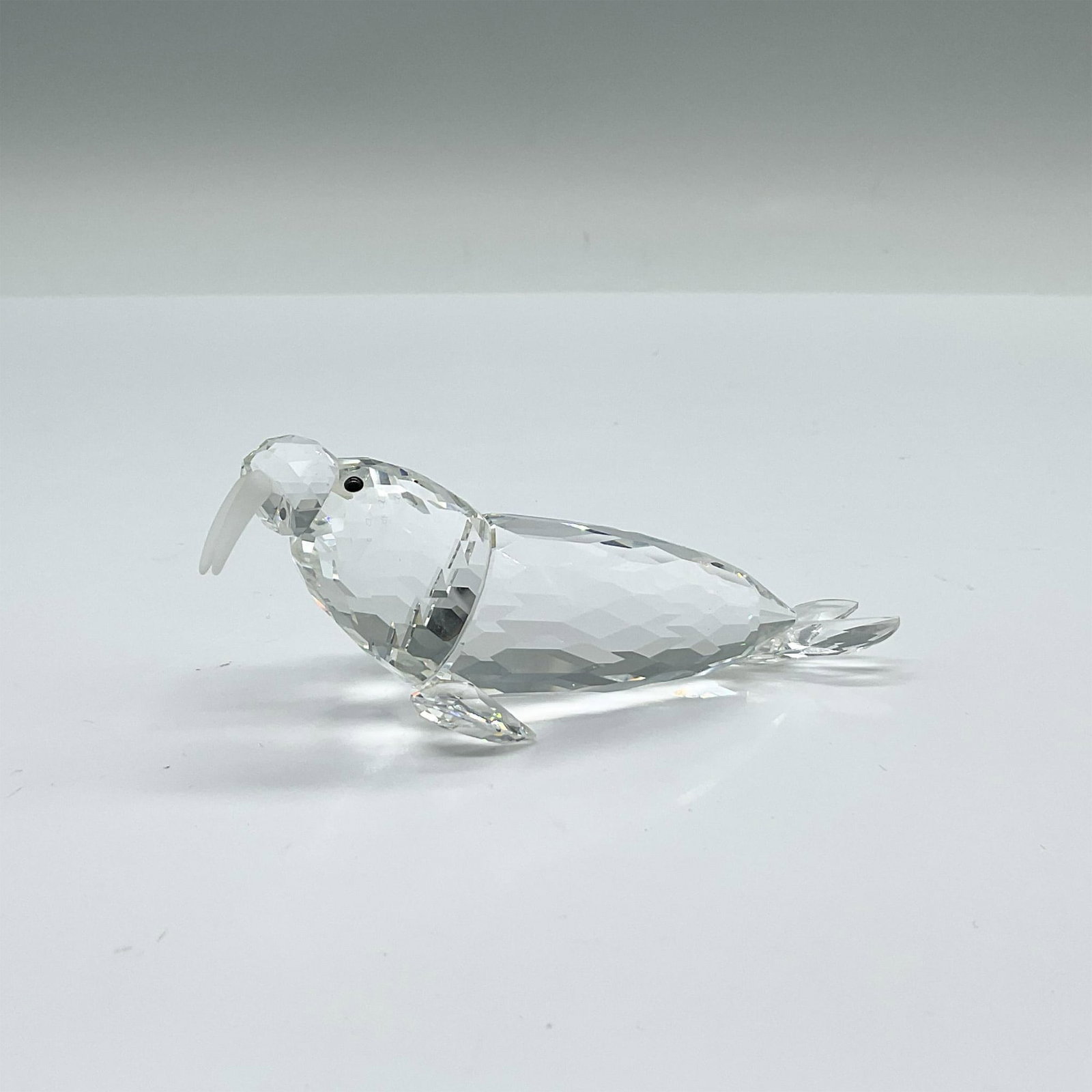 Swarovski Silver Crystal Figurine, Walrus: From the Kingdom of Ice and Snow group. A clear facetted crystal marine mammal with frosted tusks and black crystal eyes. Swarovski swan etched marking. This item has its original box: 3.25"W x 6.5"H.