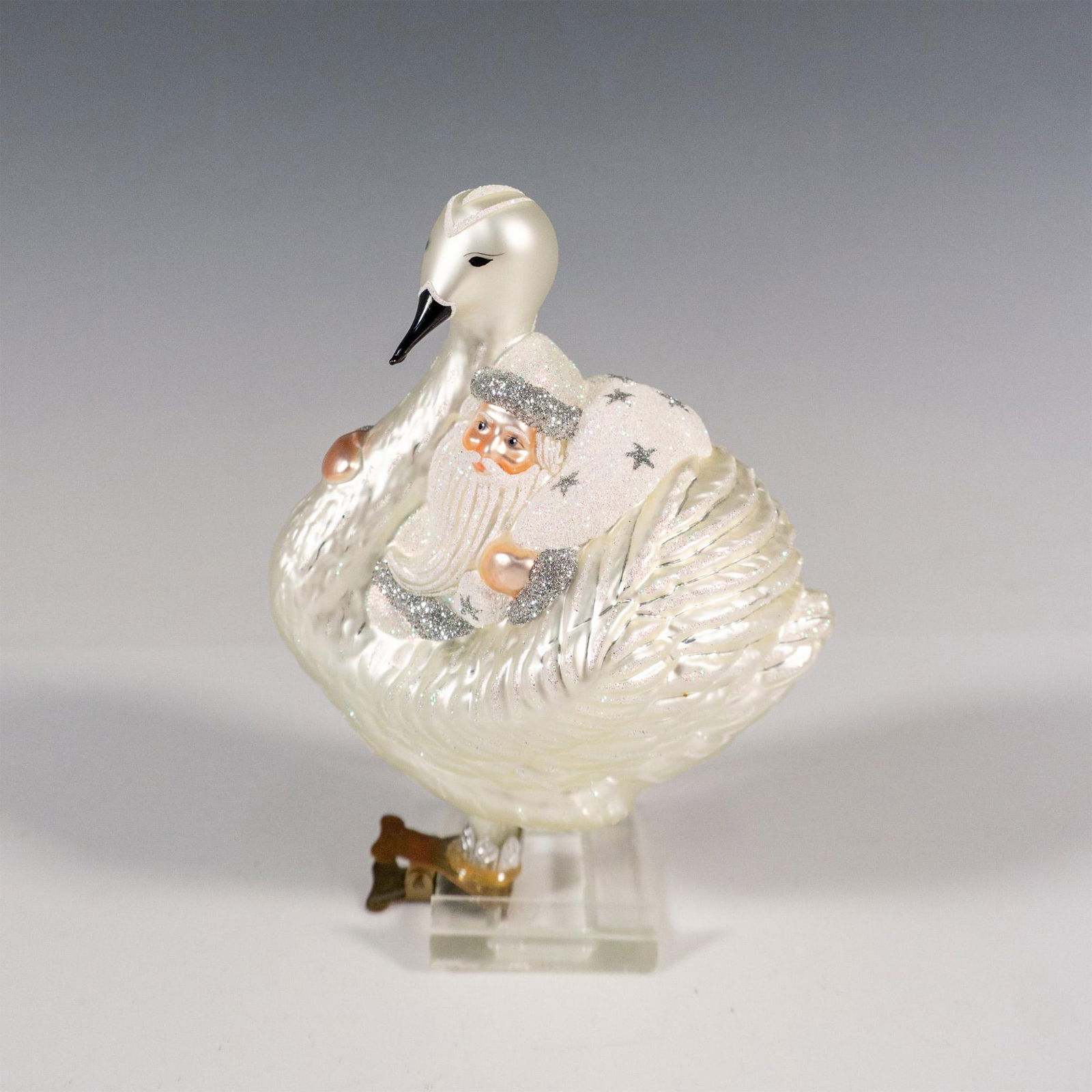 Patricia Breen Christmas Ornament, Swan Boat Santa: From the late 1870s, these foot-propelled boats, adorned with large swans covering the captain's area, are the only of their kind in the world. Inspired by this unique vessel, this glass ornament show