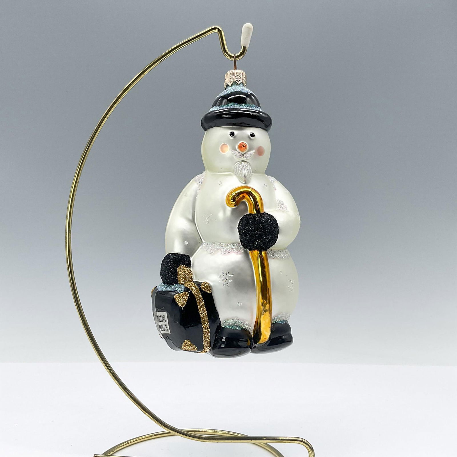 Patricia Breen Snowman Ornament Neiman Marcus: Professor Mercury snowman ornament. This distinguished snowman sports a pearl-white hue with a glossy black hat, mittens, and shoes. He holds a gold-toned cane with frosty iridescent glitter highlight