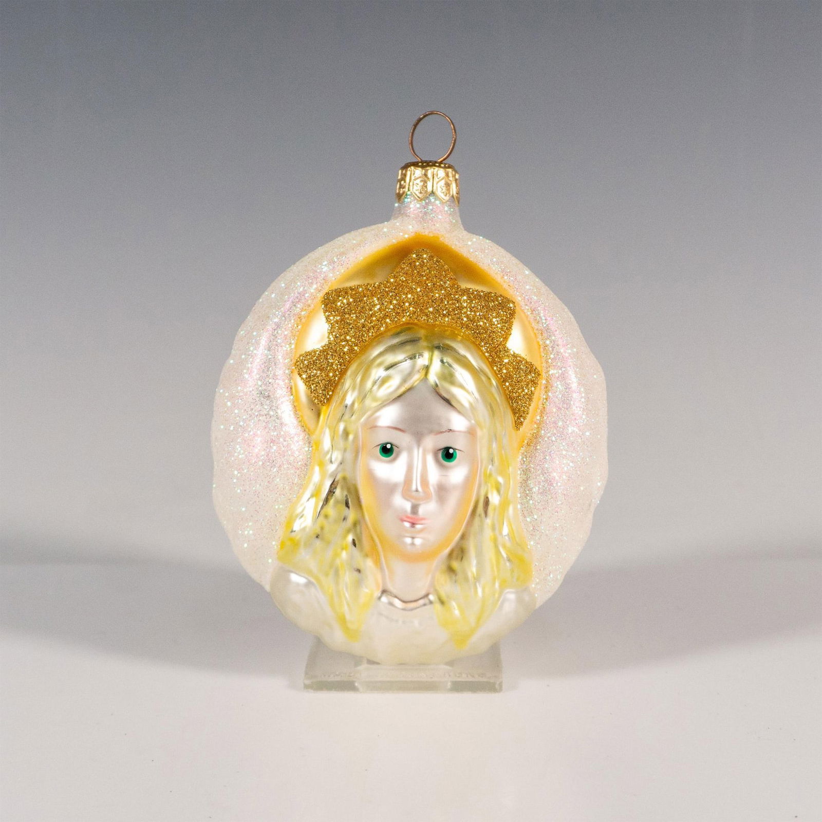 Patricia Breen Christmas Ornament, Angel of Light: Exuding elegance, this hand-painted design, this glass ornament showcases an angelic face in shimmering gold and pearl-white tones. Originally crafted exclusively for the Birmingham crisis center. Iss