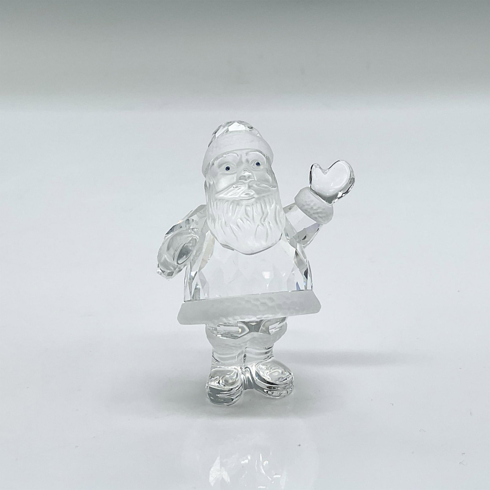 Swarovski Silver Crystal Figurine, Santa Claus: Clear faceted crystal figurine of Santa with blue eyes and frosted crystal accents. Swarovski mark. This item has its original box: 4"L x 4"W x 3"H. Dimensions: 2"L x 1.75"W x 2.25"H Manufacturer: Swa