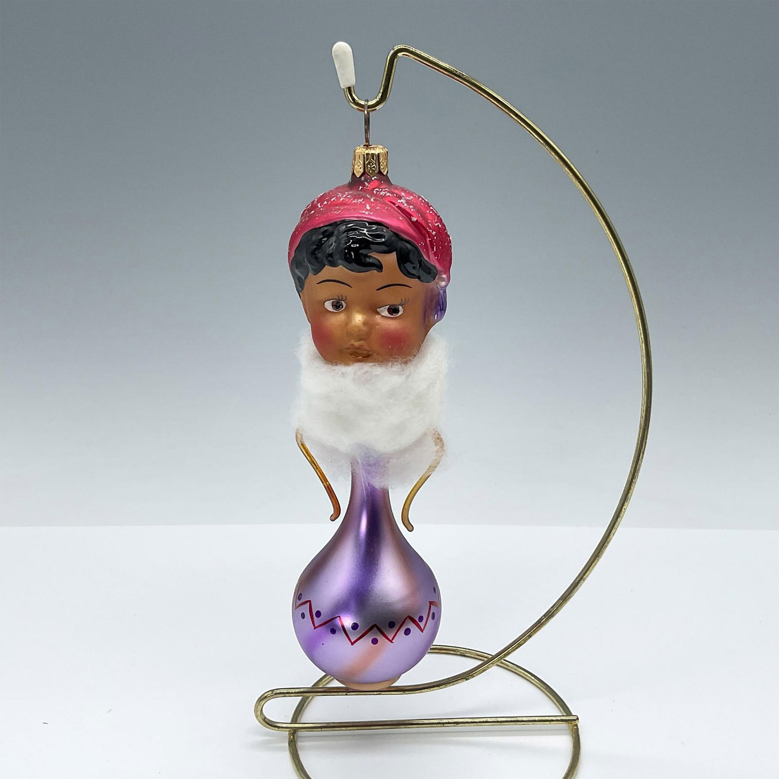Hand Blown Glass Christmas Ornament, Genie: Gorgeous hand-blown and hand-painted glass ornament portraying a genie emerging from a purple bottle, with a fluffy cloud creating the illusion of smoke. The vase features delicate double handles, add