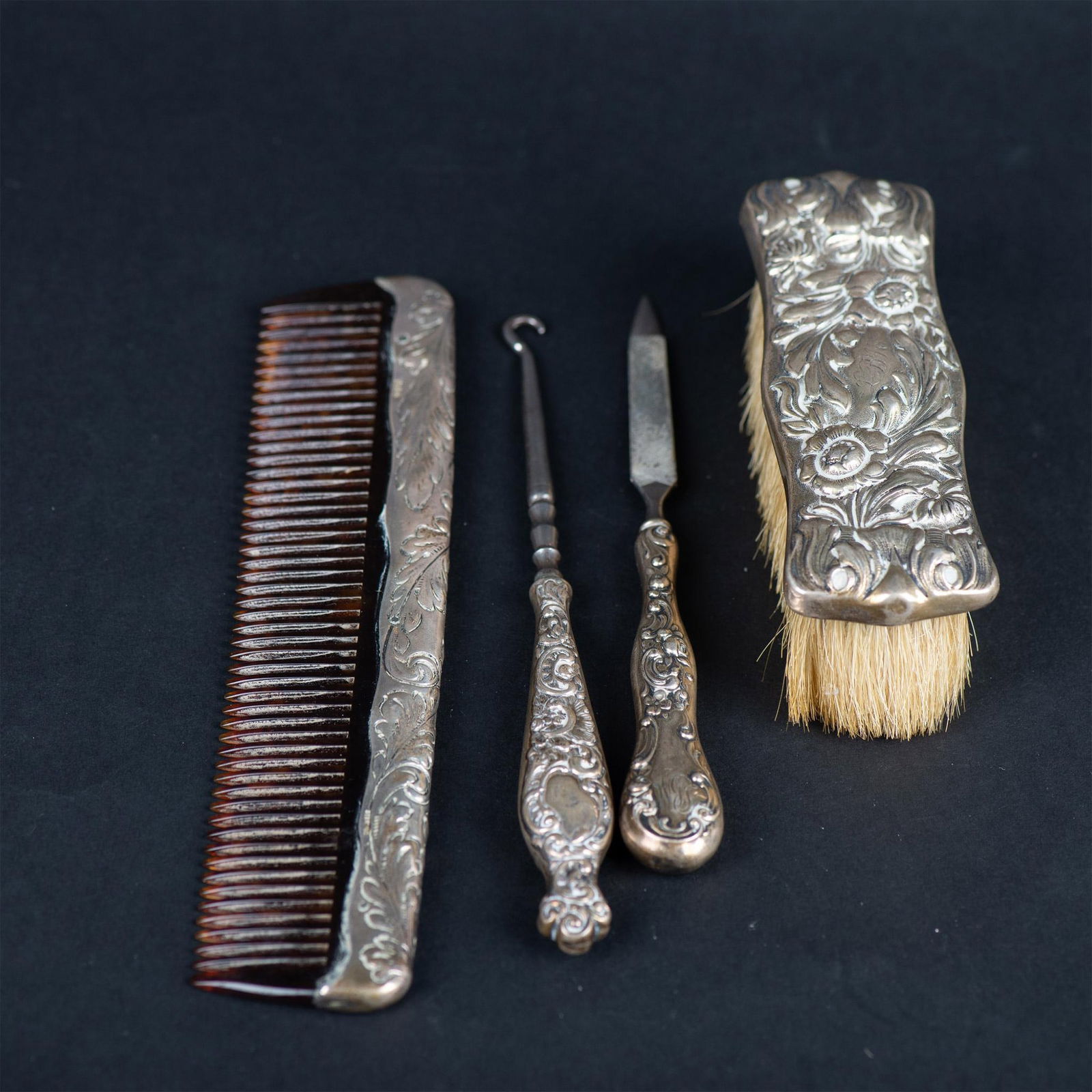4pc Antique Sterling Silver Beauty Grooming Set: Tortoise shell comb with a sterling silver spine is 8"L. The brush is 5"L x 1.75"W x 1.5"H. The file is 6.75"L. The button hook is 7.25"L. All of the pieces are marked sterling and monogrammed with th