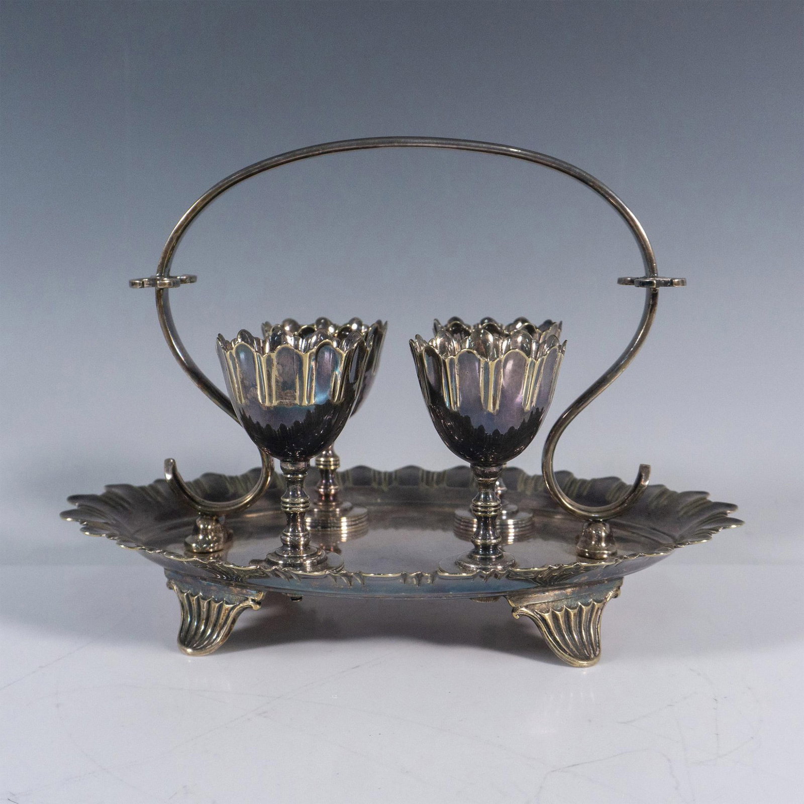 5pc Philip Ashberry & Sons Silverplated Caddy w/ Egg Cups: The footed caddy tray with basket handle has silverplate maker hallmarks on the bottom and measures 8.5"L x 6"W x 6"H. The egg cups measure 1.75"dia. x 2.75"H. The set has a beautiful patina. Philip A