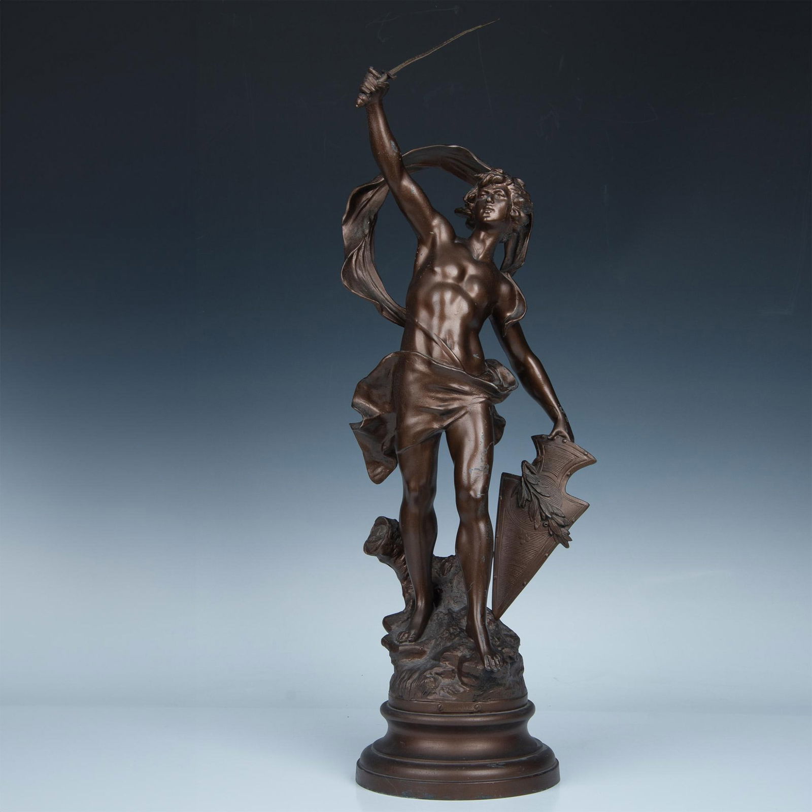 After Auguste Moreau Bronze Plated Sculpture, Patrie: A metal figure, representing country, holding a sword and shield in a bronze finish. This piece is in the style of the French sculptor, Auguste Moreau (1834 - 1917), who was best known for his bronze-