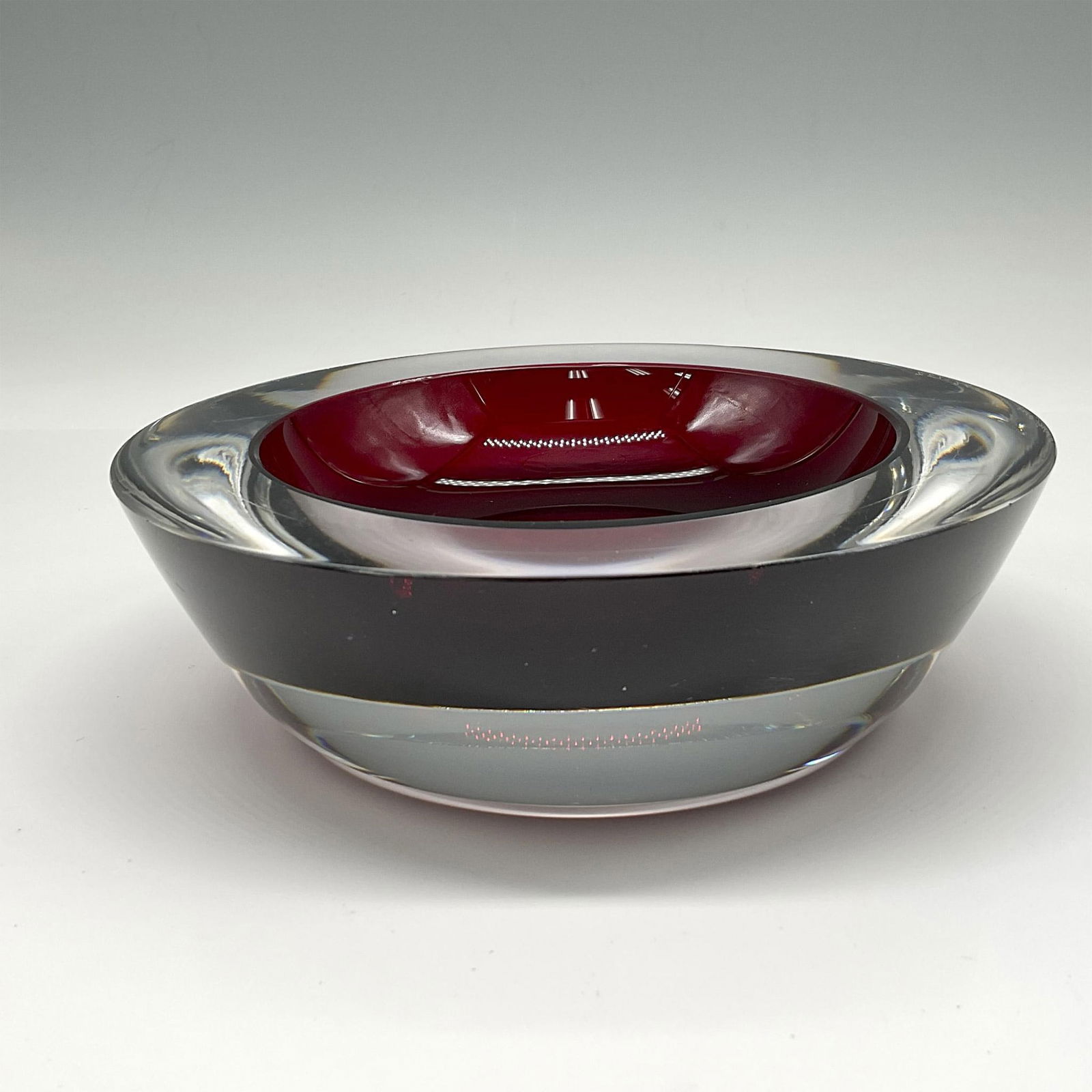 Orrefors Crystal Nils Landberg - Coin Dish: Substantial deep red crystal with clear crystal base with low concave in center. Orrefors mark. Dimensions: 2"H x 6.25" dia. Manufacturer: Orrefors Country of Origin: Sweden