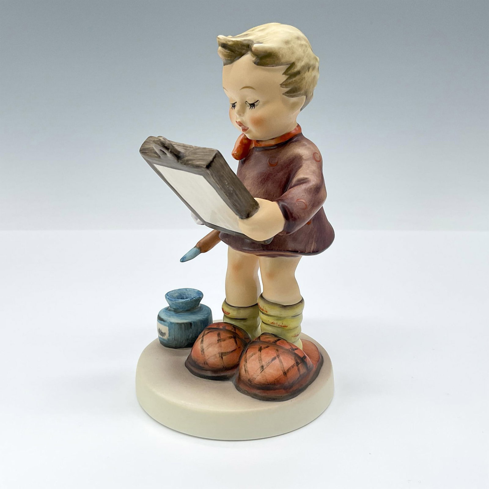 Goebel Hummel Porcelain Figurine, Art Critic: This adorable first-issue figurine portrays a painter with his paintbrush and paper, observing his finished canvas. It features a matte finish with brown, red, and orange coloration. TMK#6. Goebel bac