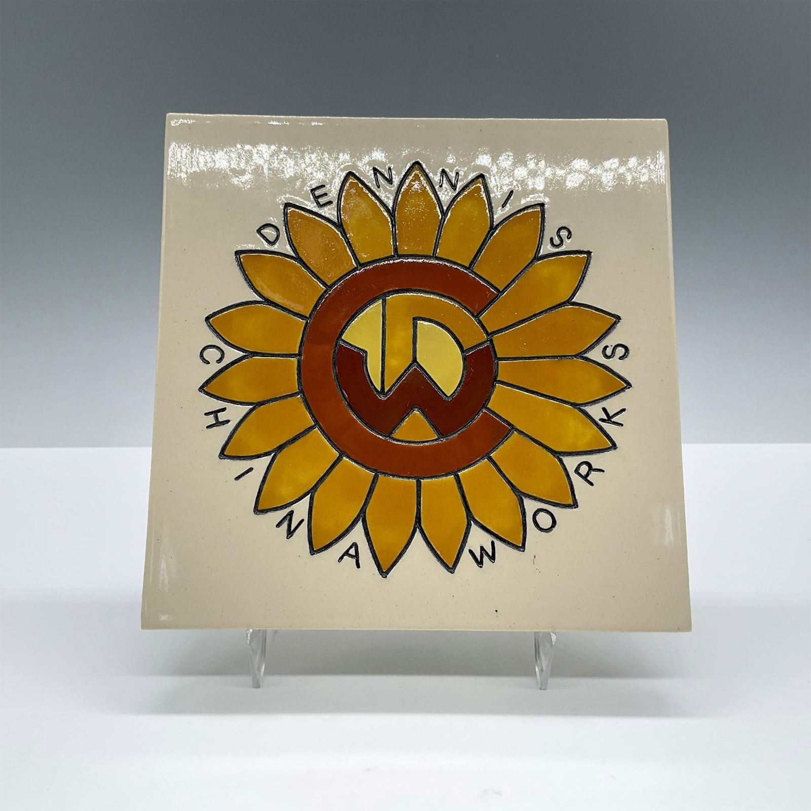 Dennis China Works Sunflower Tile: Beautiful heavy porcelain tile, features an orange sunflower with a symbol. DCW backstamp. Dimensions: 0.5''L x 6''W x 6''H