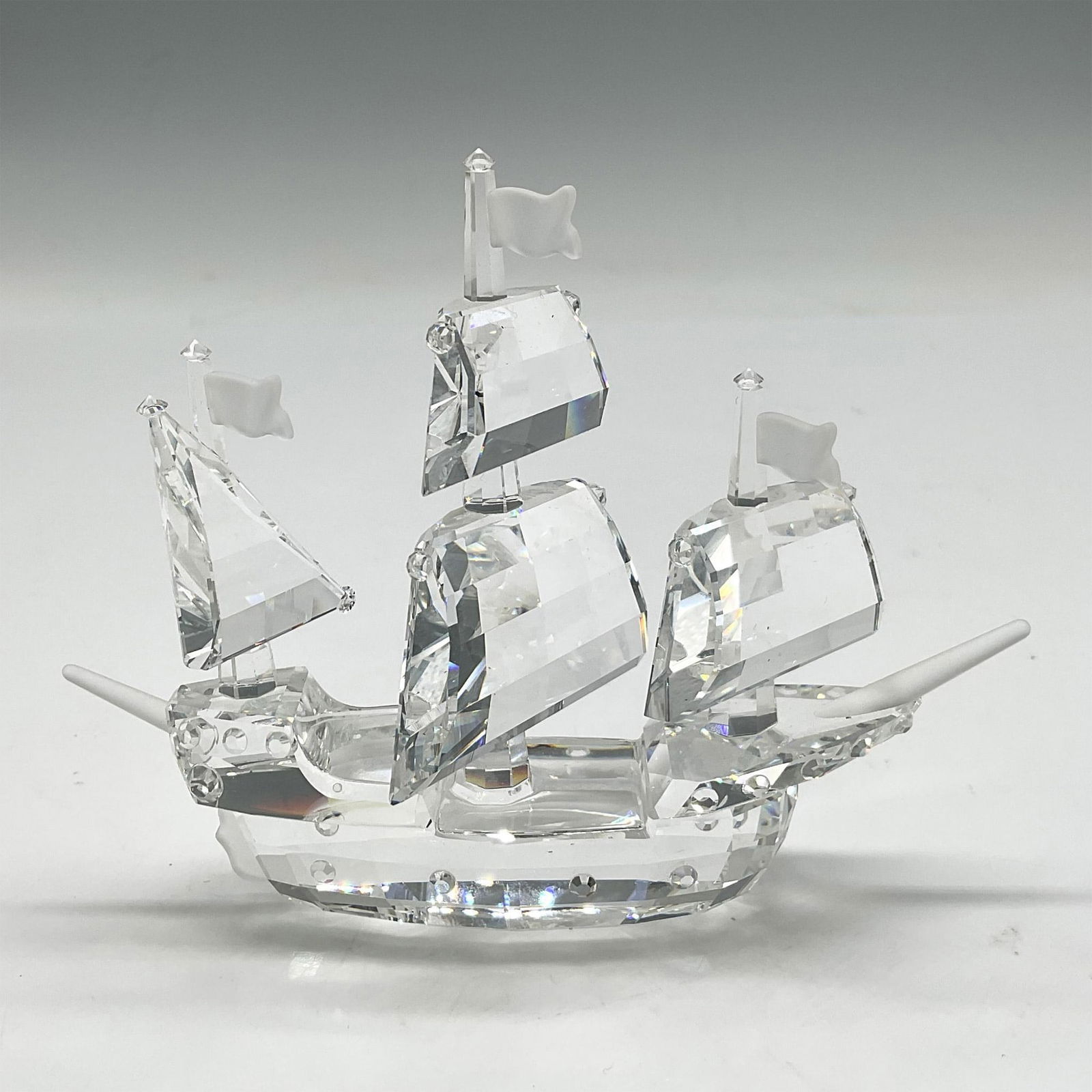 Swarovski Silver Crystal Figurine, Santa Maria: Part of the When We Were Young series, this ship is designed with faceted sails, clear crystal base and has frosted crystal flags. Swarovski backstamp. 7473 000 003. This item has its original box: 8.