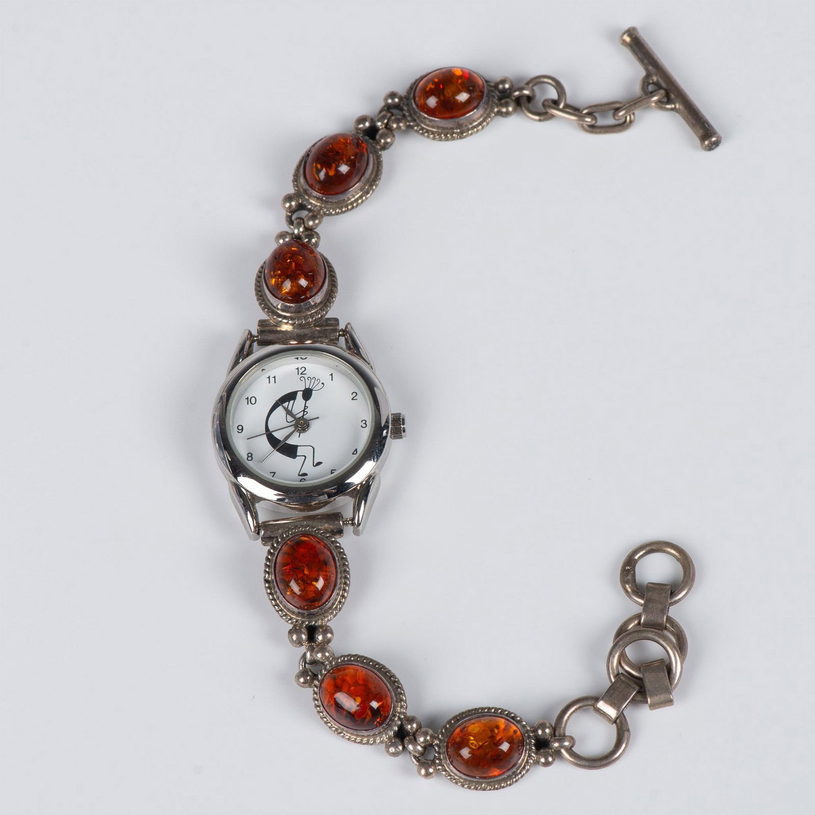 Shirley Henry Navajo Sterling Silver and Amber Kokopelli Watch: Beautiful handmade Southwestern Native American piece. The band has six amber stones set in sterling silver with artist stamp SH on the back. The stainless steel watch has a white face with a black Ko