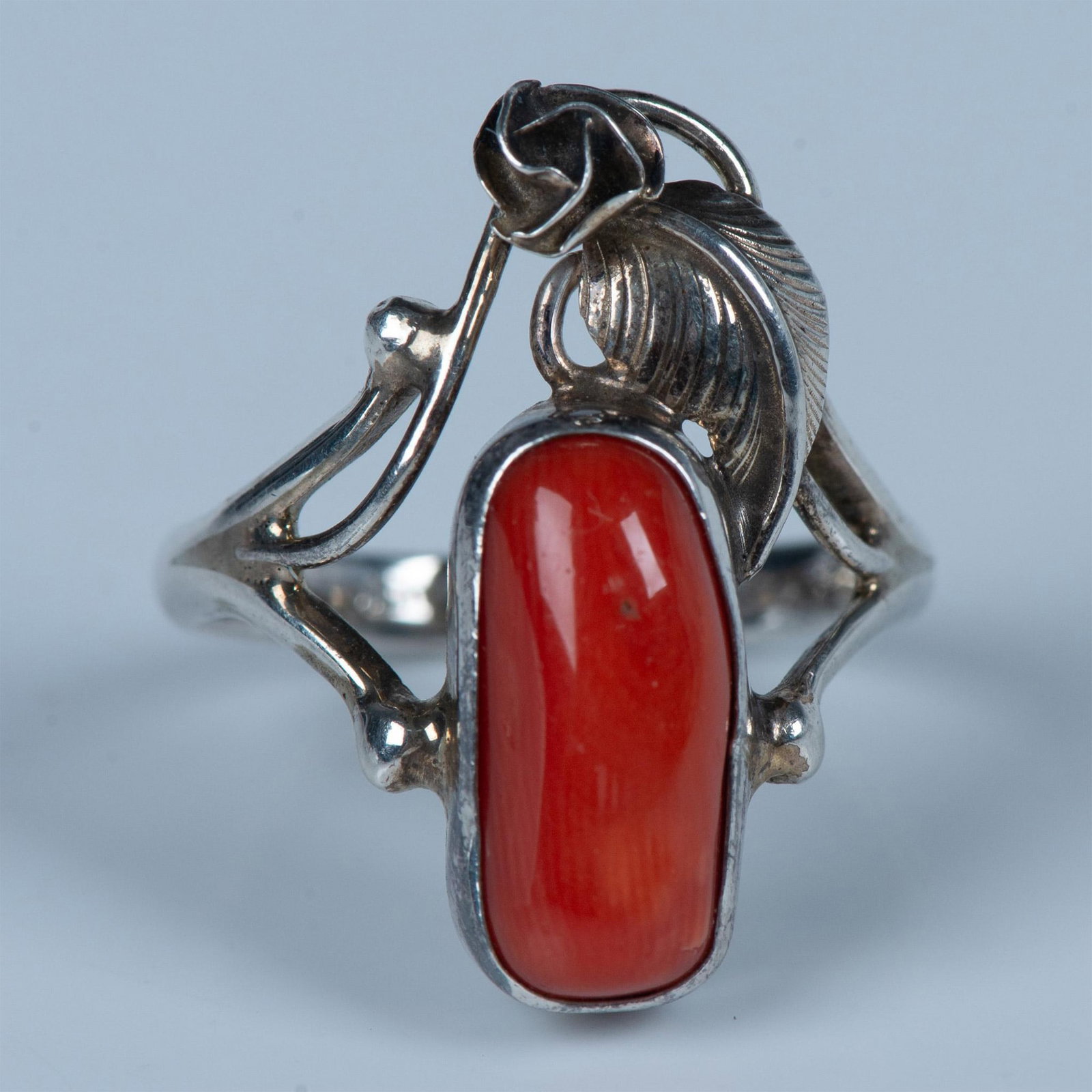 Native American Handmade Floral Sterling Silver & Coral Ring: Beautiful ring with a coral stone set in handcrafted sterling silver with a detailed flower bud and leaf. 925 stamped inside band. Size 6.5. 4g. Country of Origin: United States