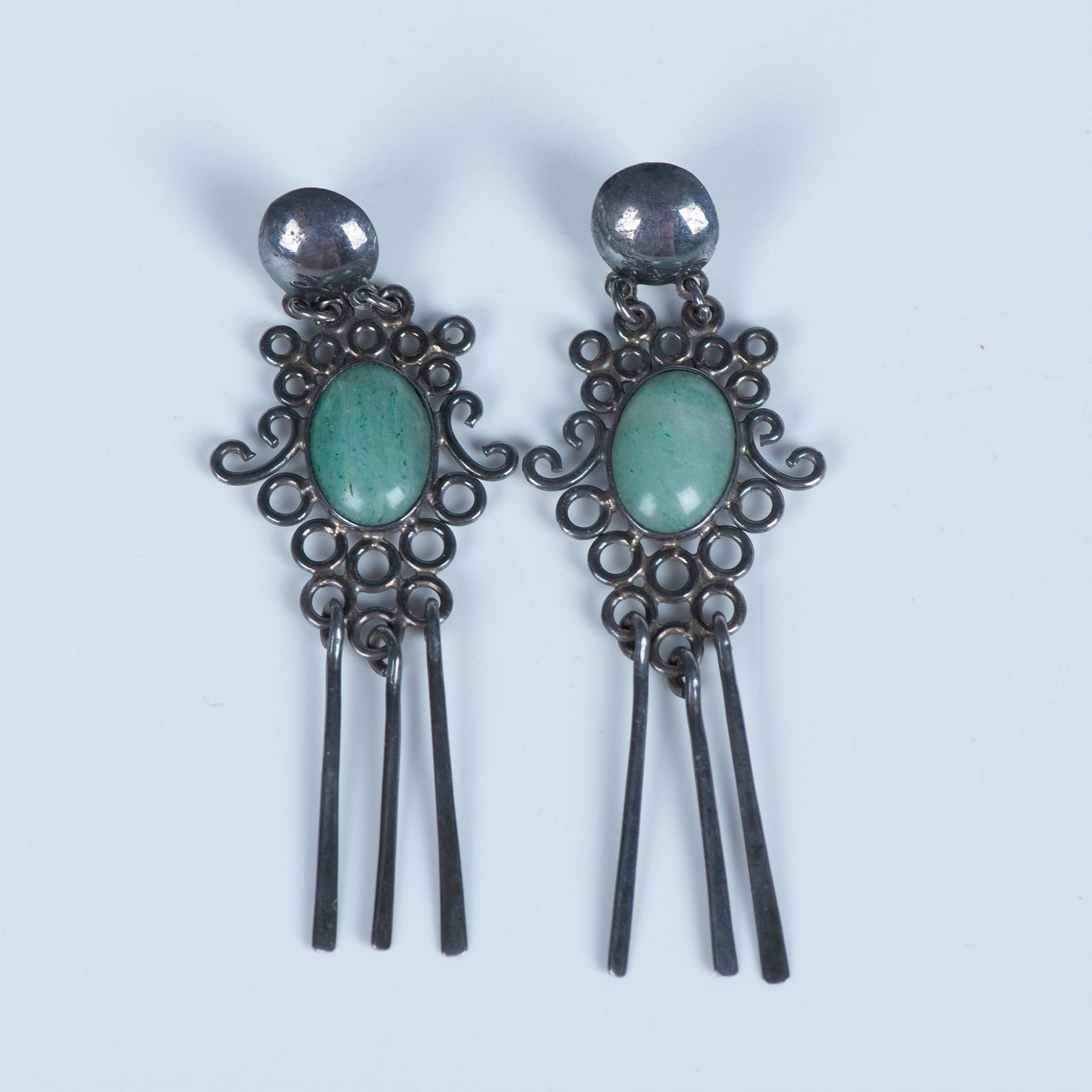 Taxco Sterling Silver & Green Gemstone Chandelier Earrings: These earrings are sterling silver set with a green stone cabochon. They are for pierced ears and the back is stamped 925 with an illegible maker's mark. Total weight is 22g. Dimensions: 3.5"L x 1.25"
